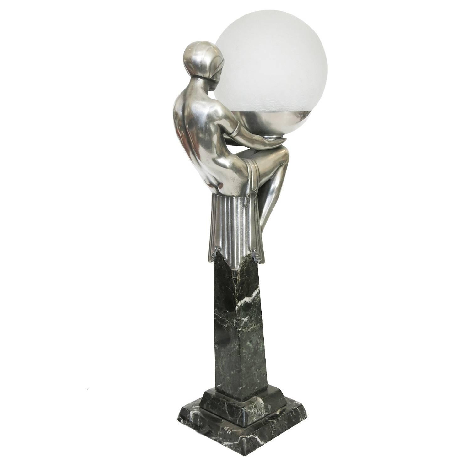 French Art Deco style flapper lamp on obelisk in the style of Max Le Verrier's work from the 1920s in France.

This gorgeous looking lamp features a casted bronze nude flapper statue with an antique silver finish. This beautifully sculpted figure