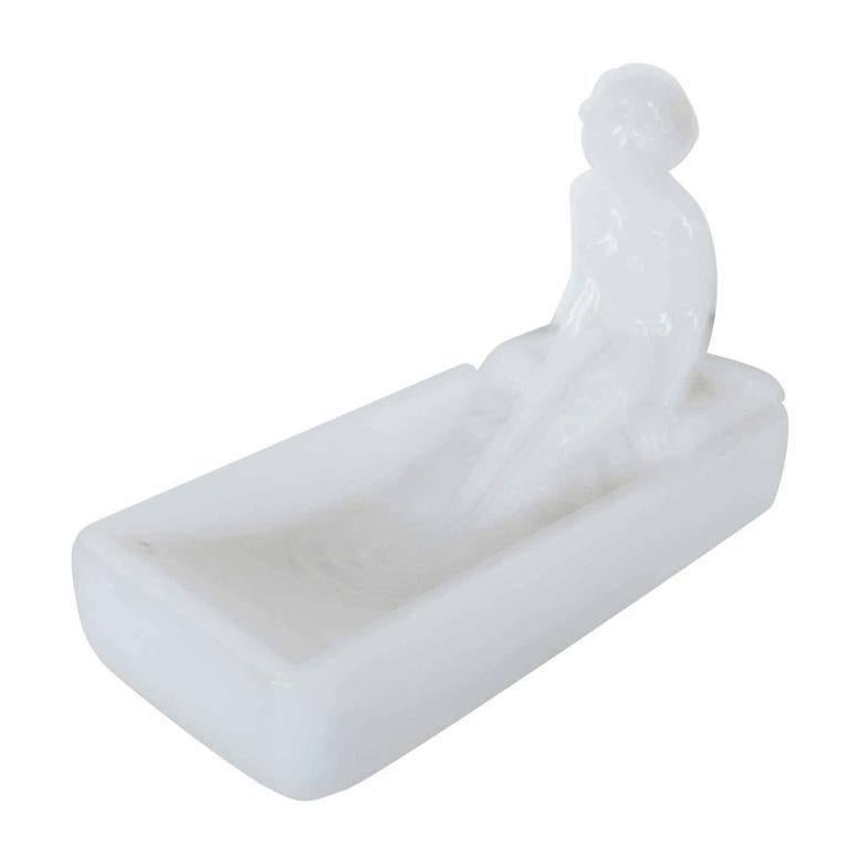 This 1970s re-edition of a 1927 Art Deco Heinrich Hoffman milk glass art glass soap dish / ring tray features a nude female figure bathing in a tub.

Condition: Excellent
Specifications: Height 2.75, width 6, depth 4
Materials / techniques: