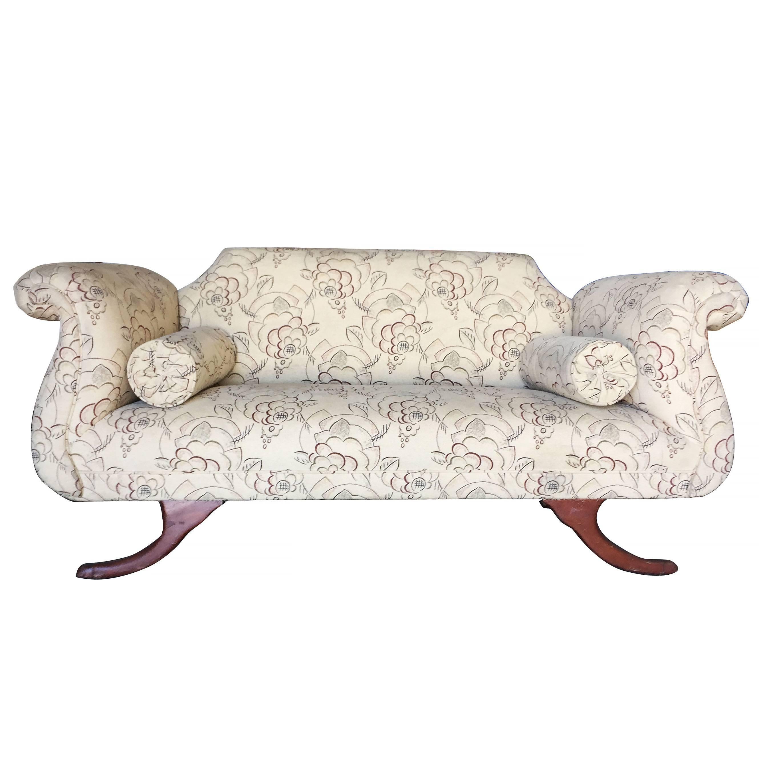Duncan Phyfe style loveseat settee with scrolling arms, floral print upholstery and matching side pillows.