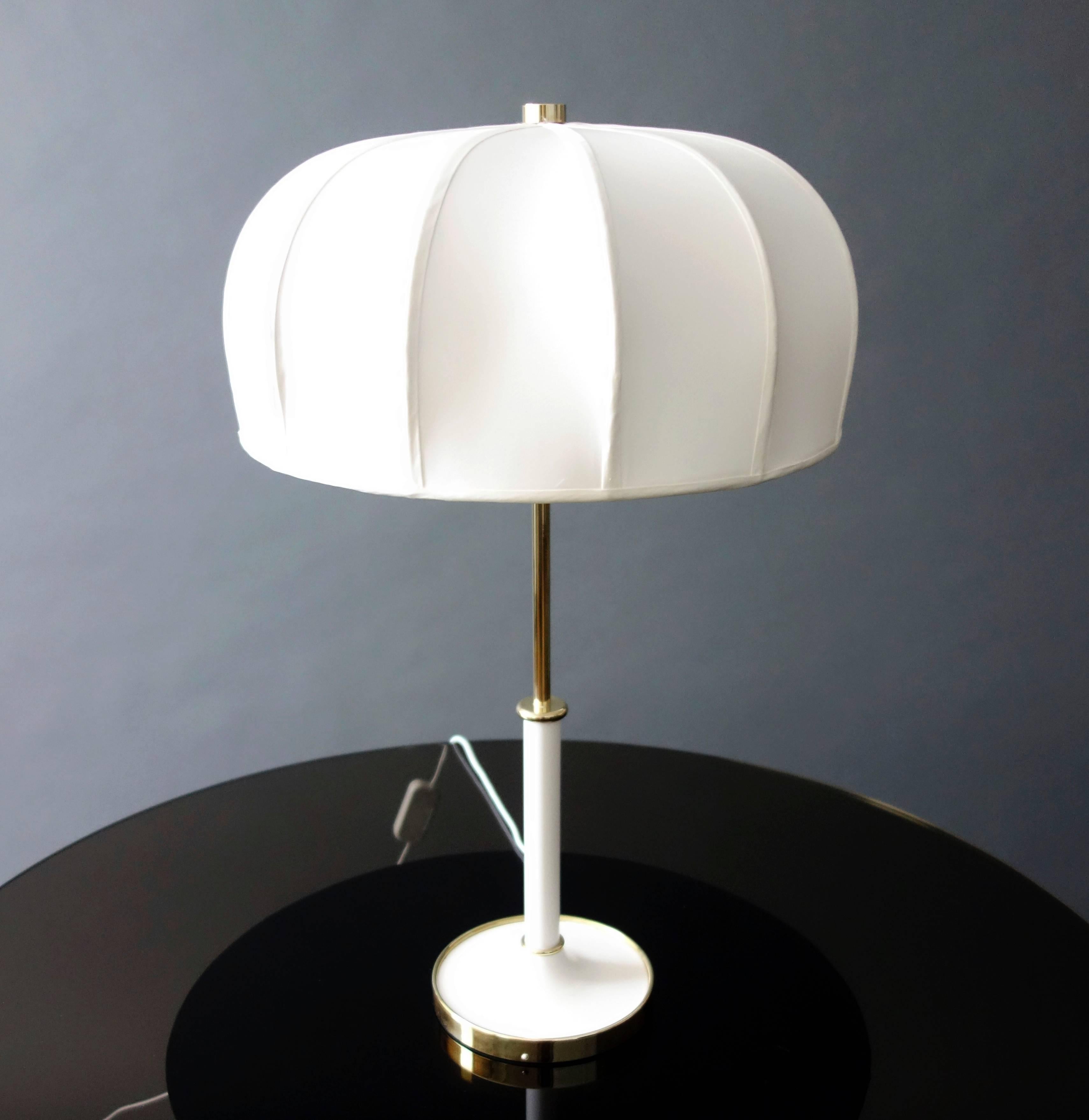 A chic and playful table lamp with a slender brass and enamel base and a silk dome shade. 

Measurements include shade.
      