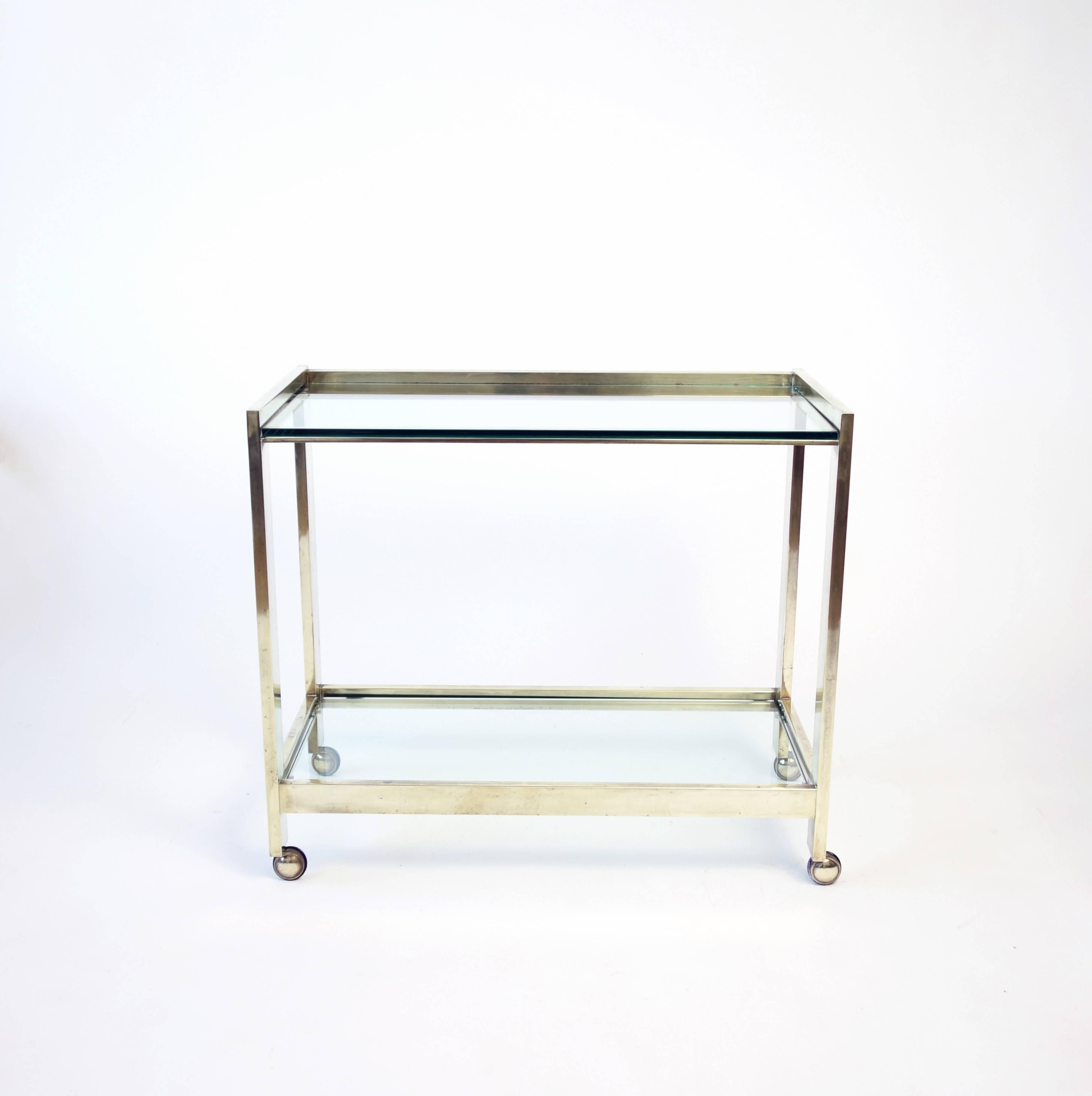 A chic, clean-lined bar cart of ample proportions, the brass surface nicely patinated.