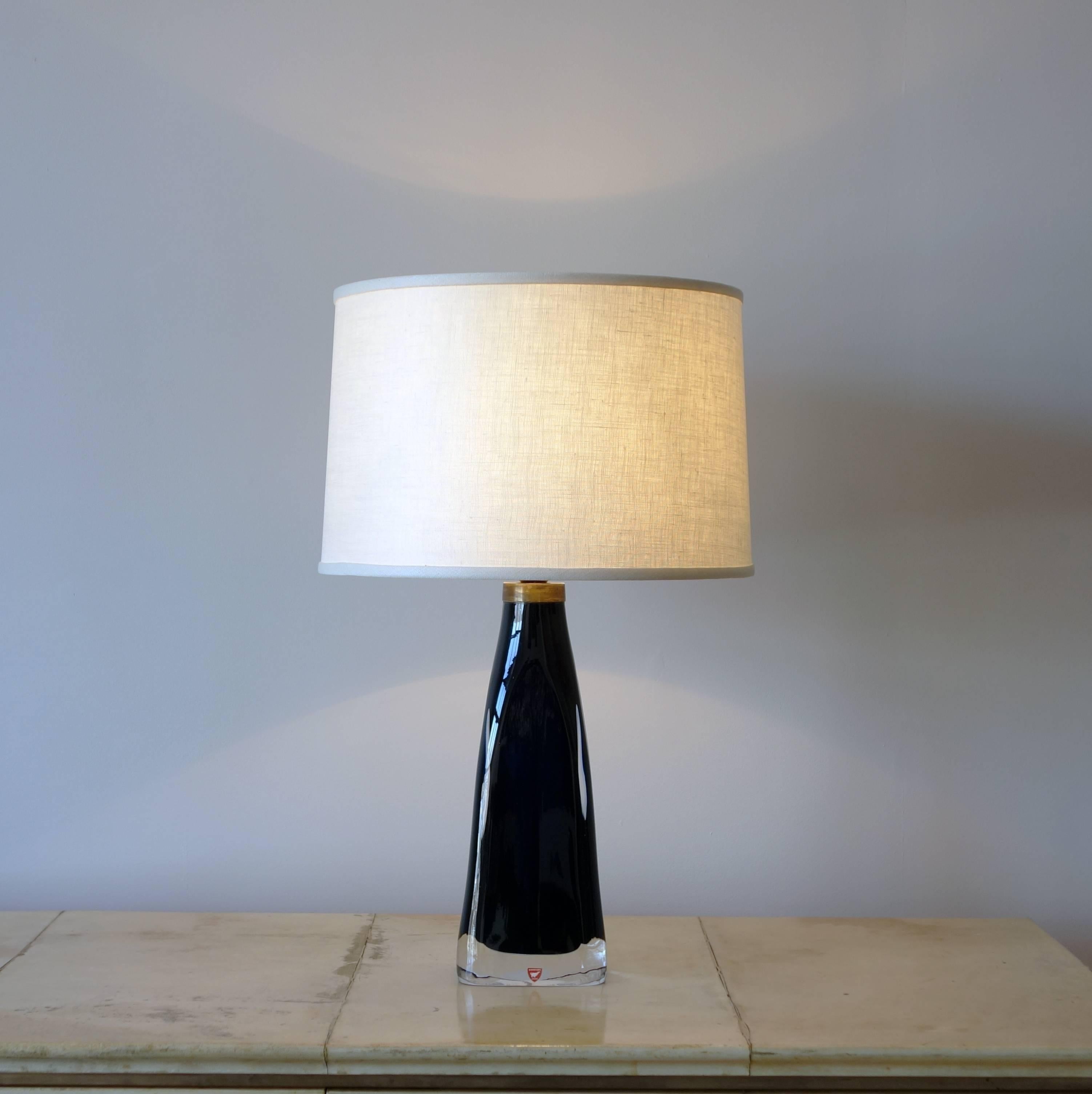 The glass is an inky dark blue, almost black, with a narrow brass collar at the top of the base. The linen shade is new, and the lamp has been rewired for the US.