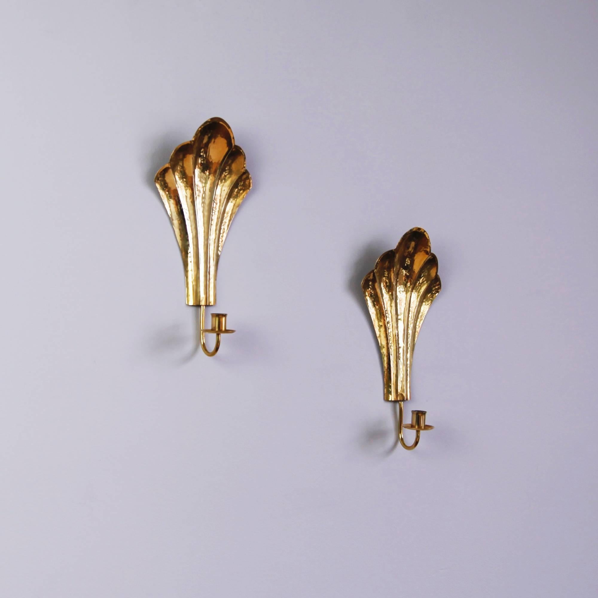 A graceful pair of Swedish Art Deco candle sconces in a warm, hammered brass. Stamped 
