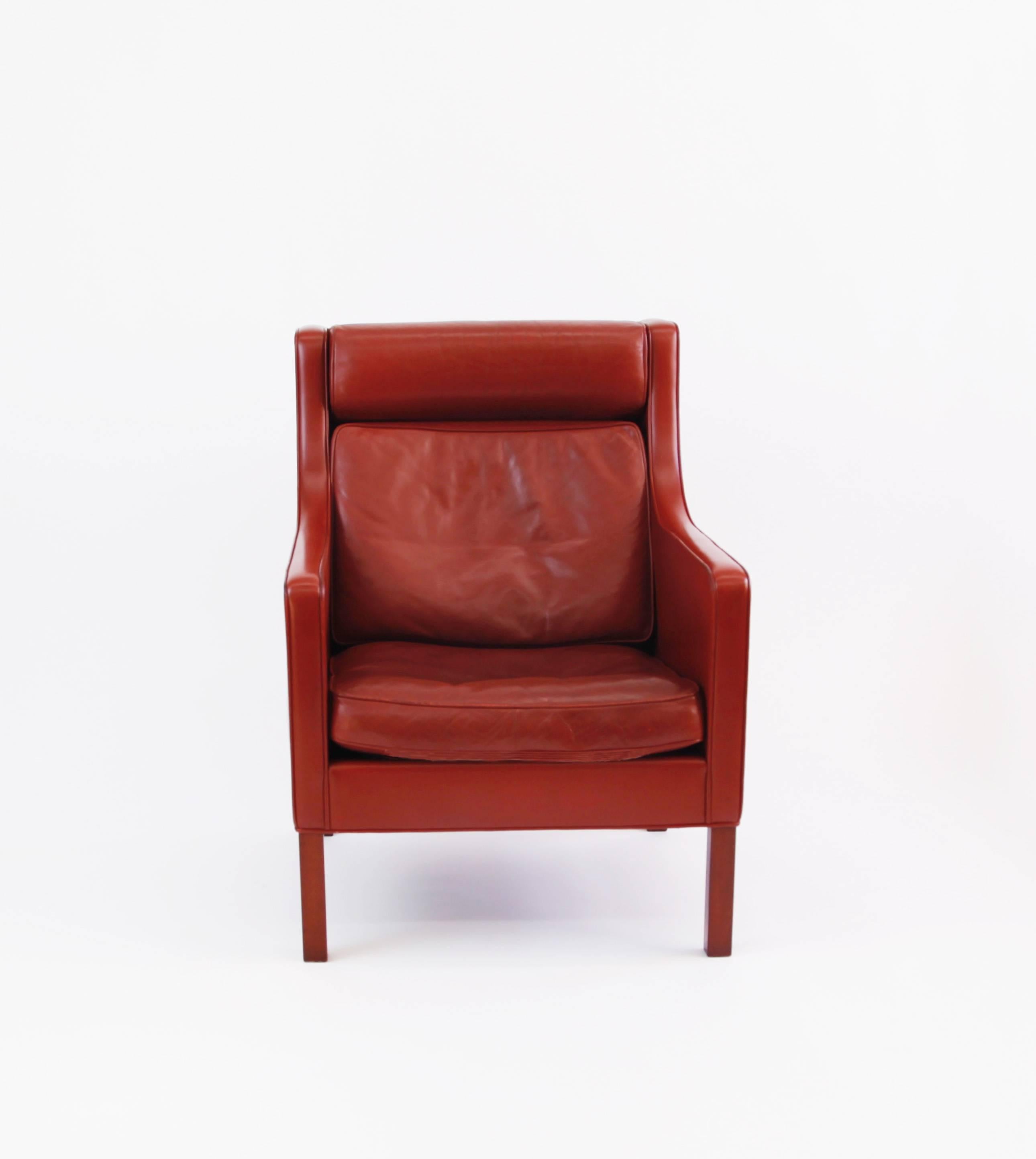 Børge Mogensen's Model 2431 armchair in an oxblood leather with hardwood legs and down seat cushion.

The original leather is nicely worn. One area of surface damage on a small part of the underside of the cushion and seat of the chair, not