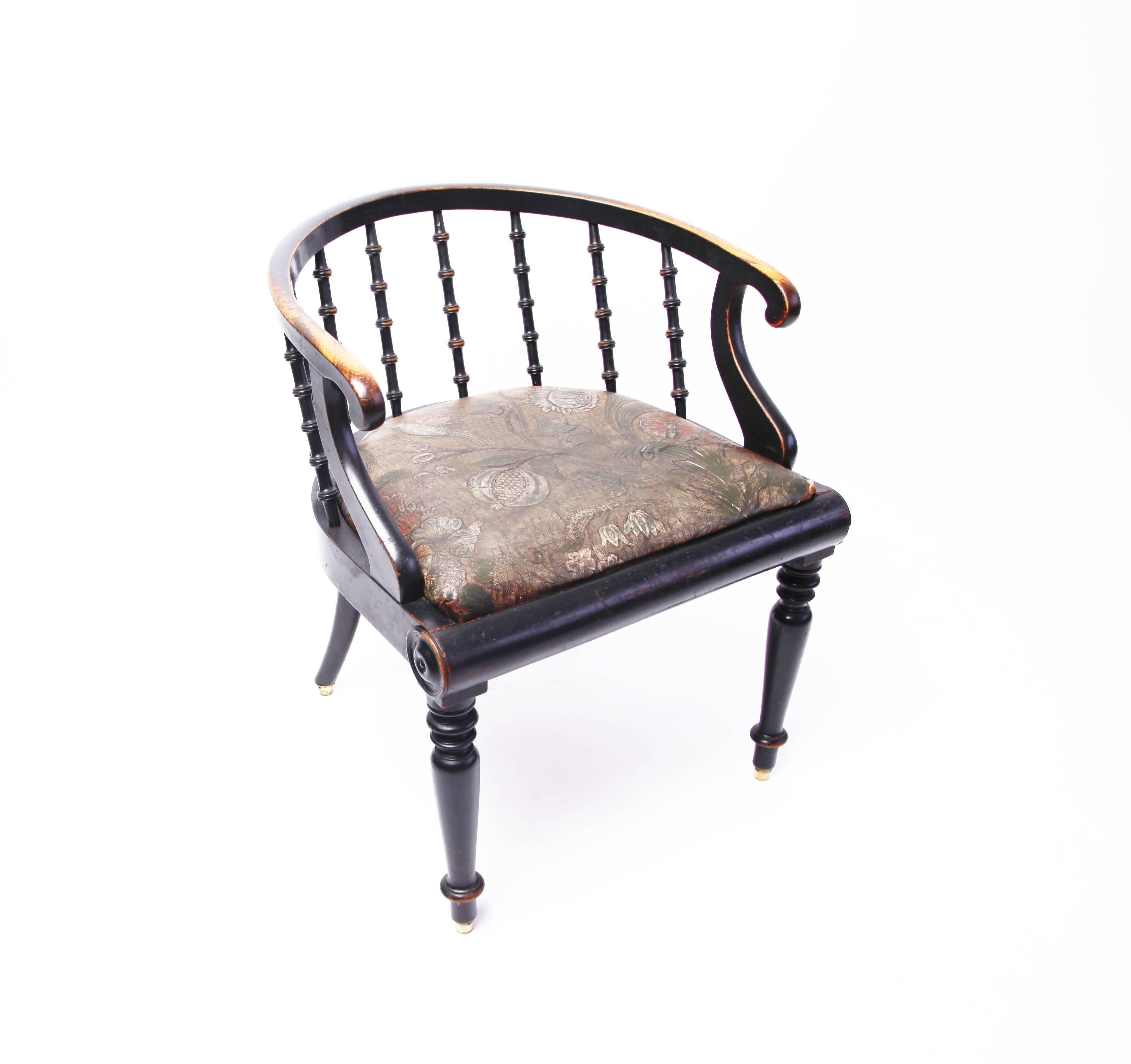 A very handsome mid-19th century ebonized armchair from Denmark. The harmony of the neoclassical form enlivened by the unusual embossed and painted leather seat richly decorated with flowers and birds.