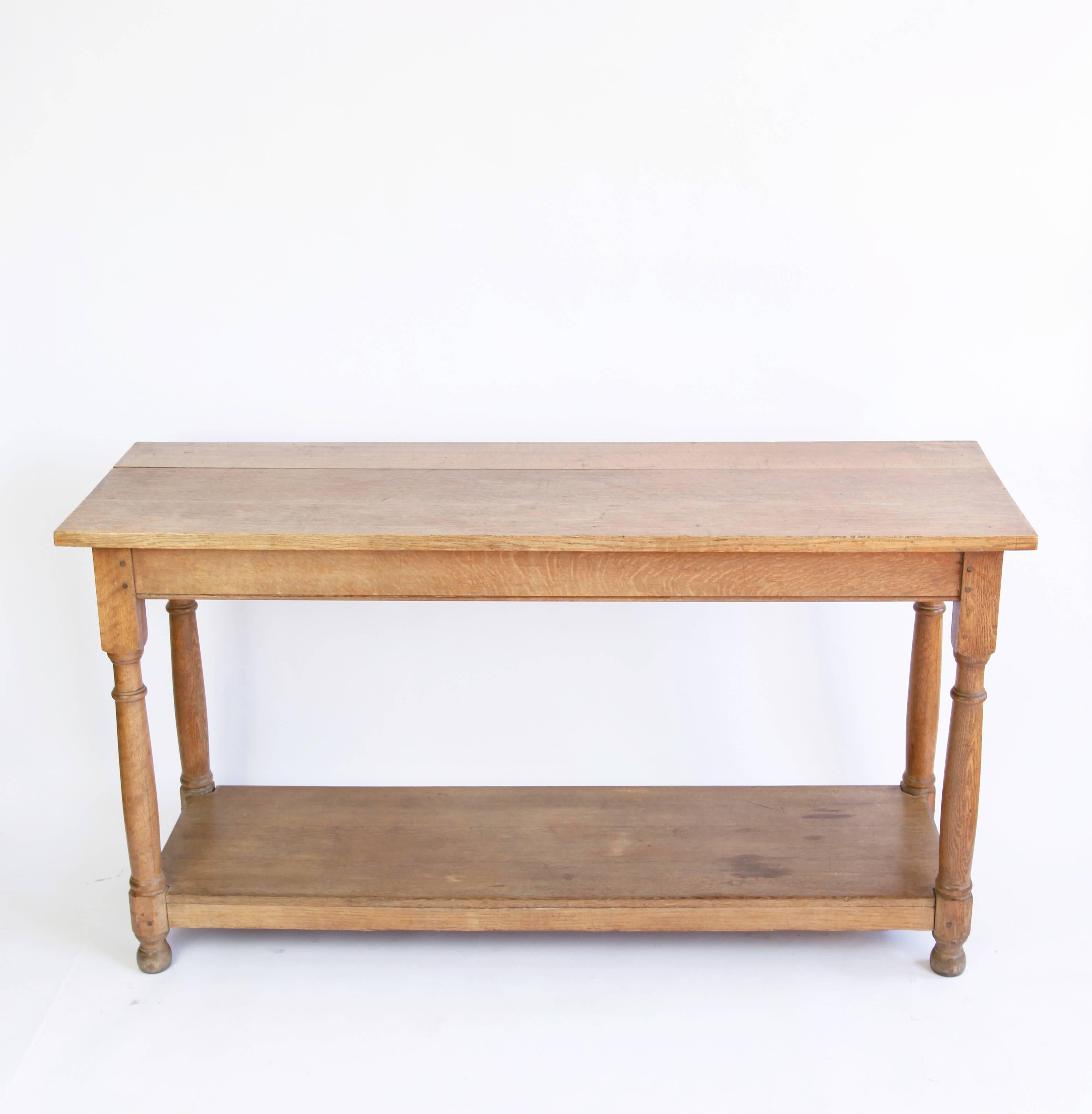 This handsome oak table with its warmly worn surface is perfect for use in a large country foyer, as an island in a roomy kitchen or sideboard in a dining room.