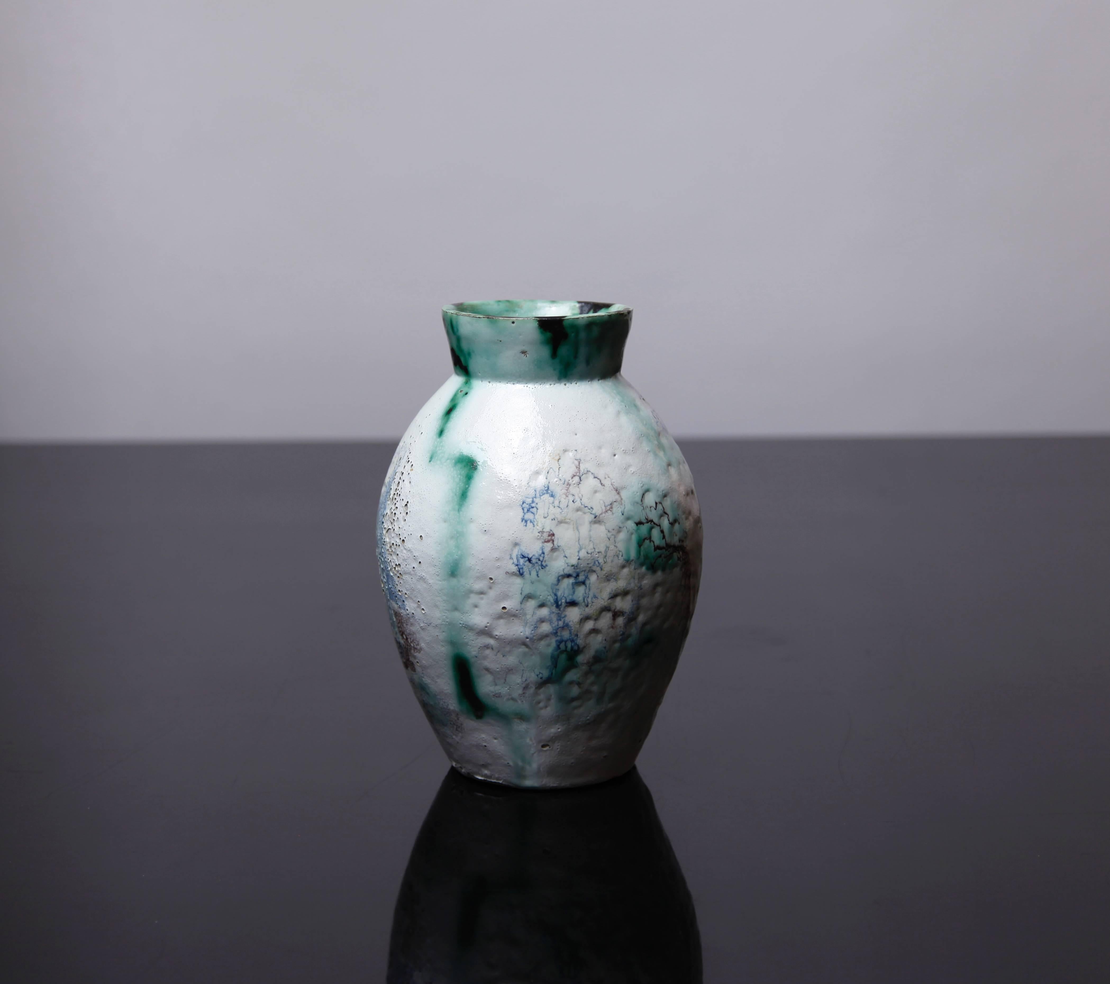 This ovoid-form vase is decorated with vivid aquatic blue and green glazes in a dynamic abstract design on white ground.
