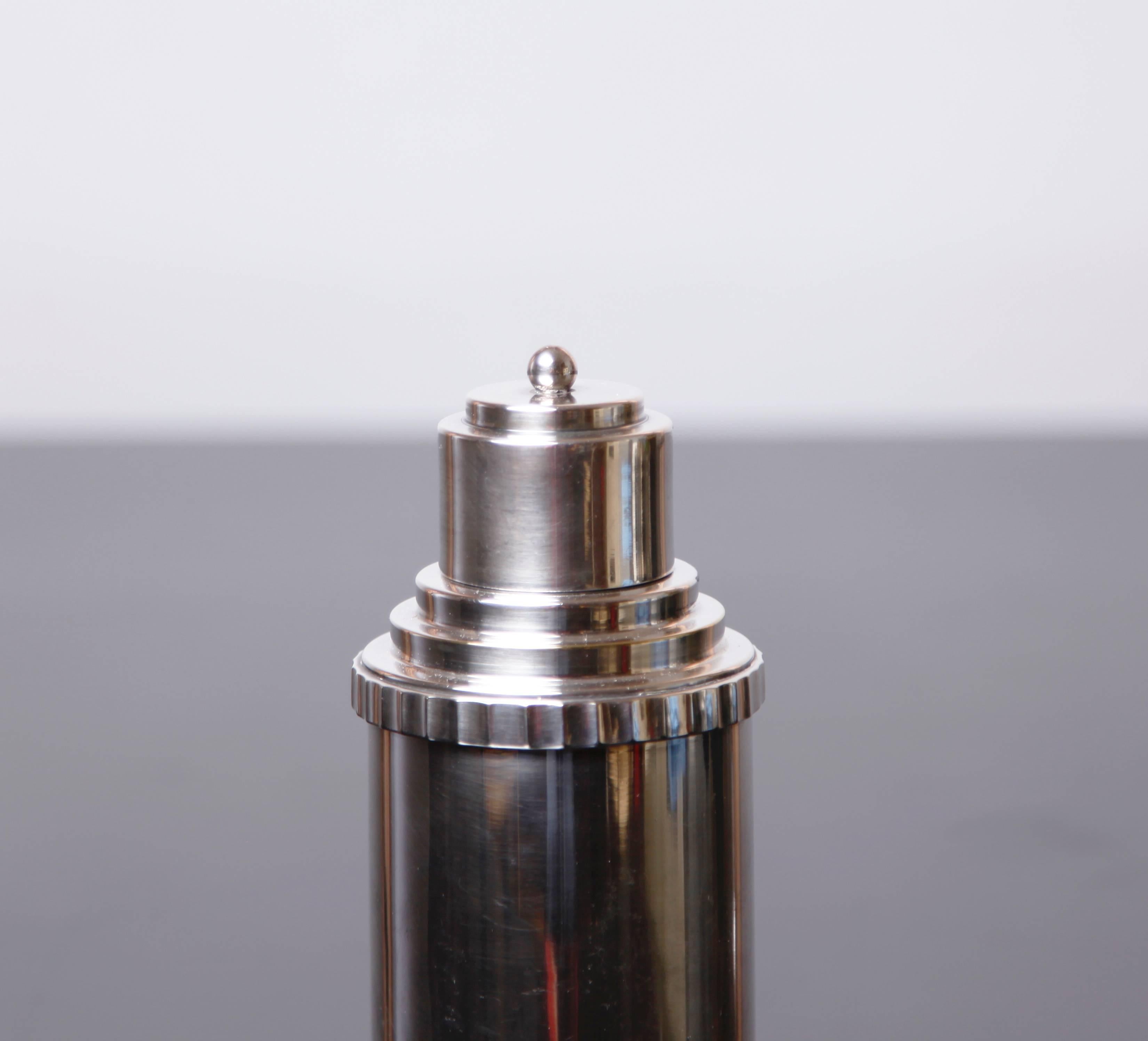 A silver plated cocktail shaker from the first quarter of the 20th century, with the same idealized Industrial glamour as the architecture of that period. 

In very good vintage condition, with one small dent on the side.