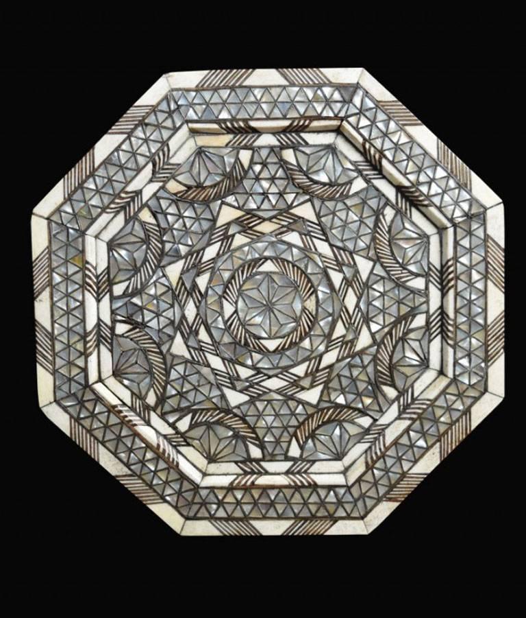 

Mother-of-pearl bone and silver inlaid coffee table of octagonal form, standing on eight arched bracket-form legs, decorated throughout with geometric interlace in mother-of-pearl, silver and bone.

Dimensions:

Height 19 inches.

Width 14