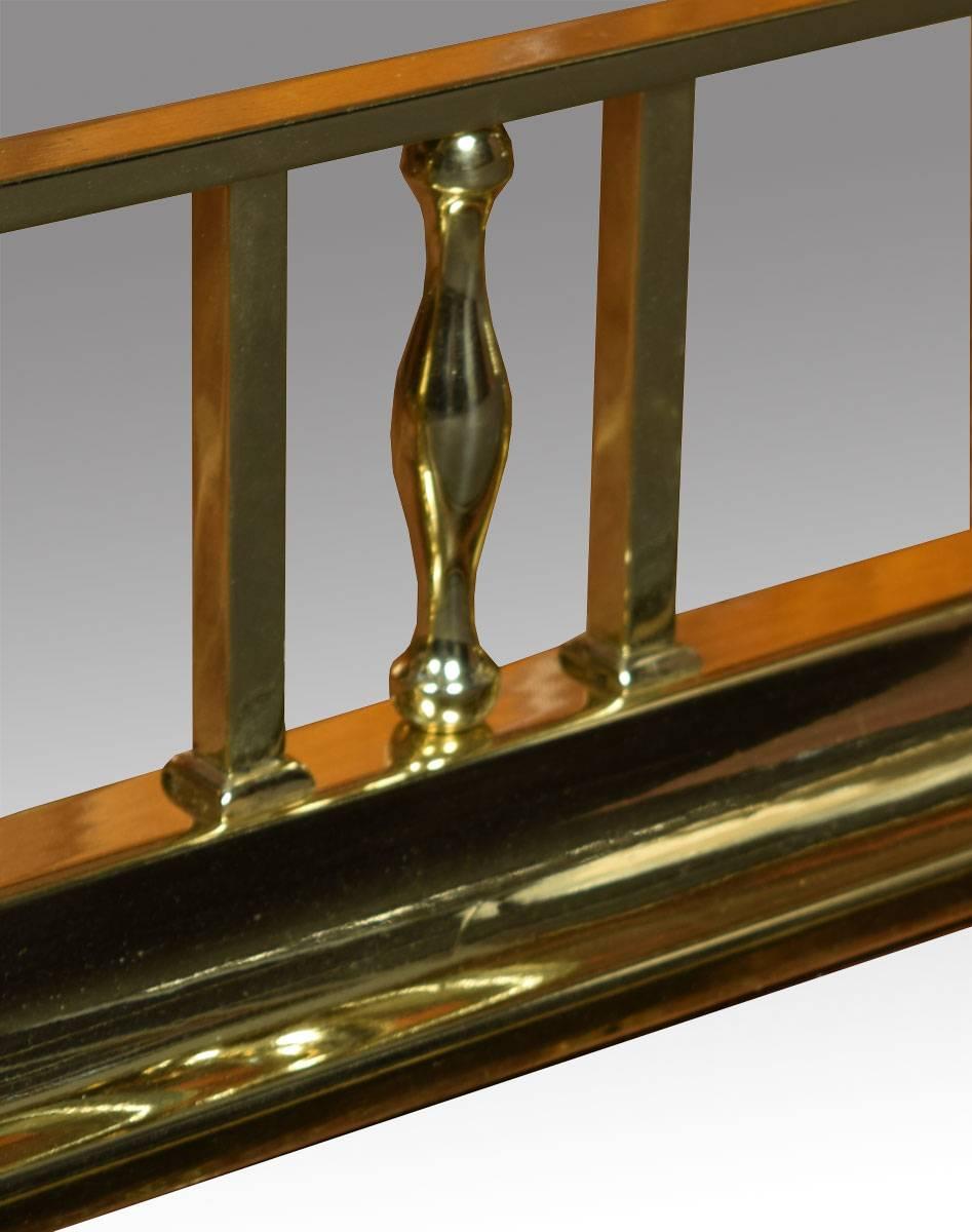 Early 20th century brass club fender, with original leather L-shaped stools above square spindles raised up on shaped plinth.

Height 18 inches.

Internal measurements:

Length 49.5 inches,

depth 13 inches.

 External