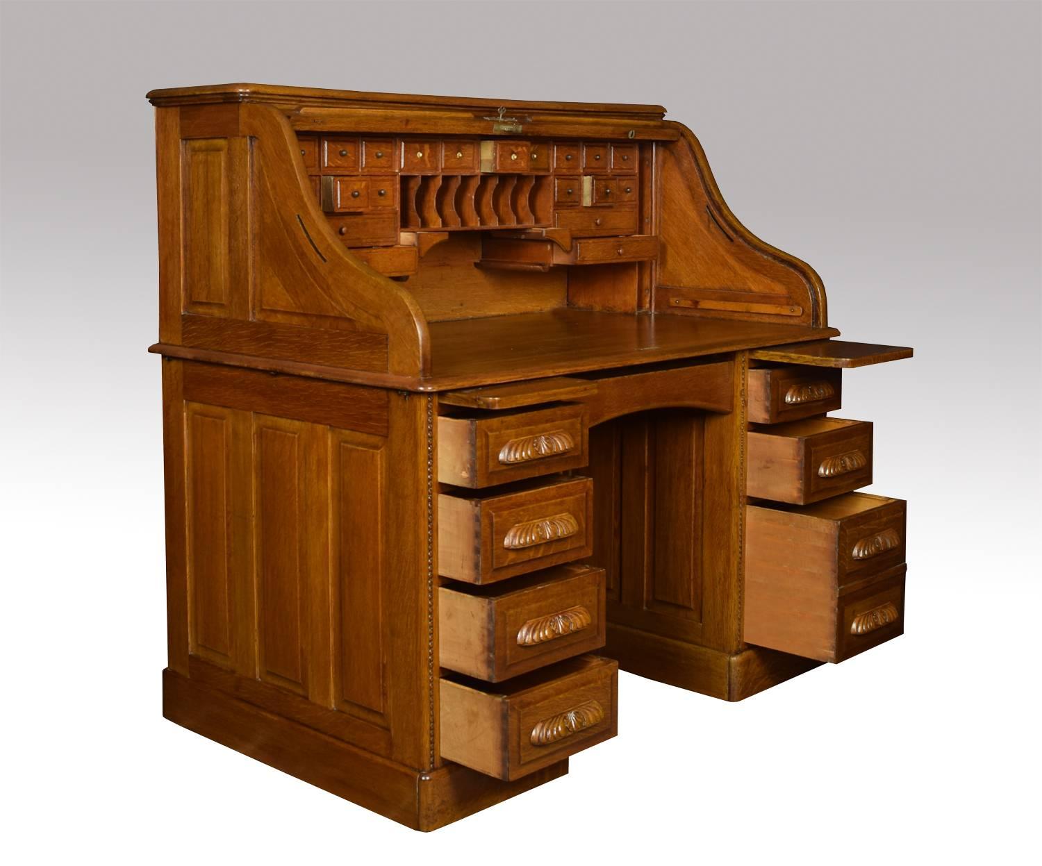 Oak double pedestal roll top desk, the high back with fitted interior of pigeon holes and drawers, the centre drawer flanked by pedestals one with four short draws the other with two short and one double draws raise up on plinth