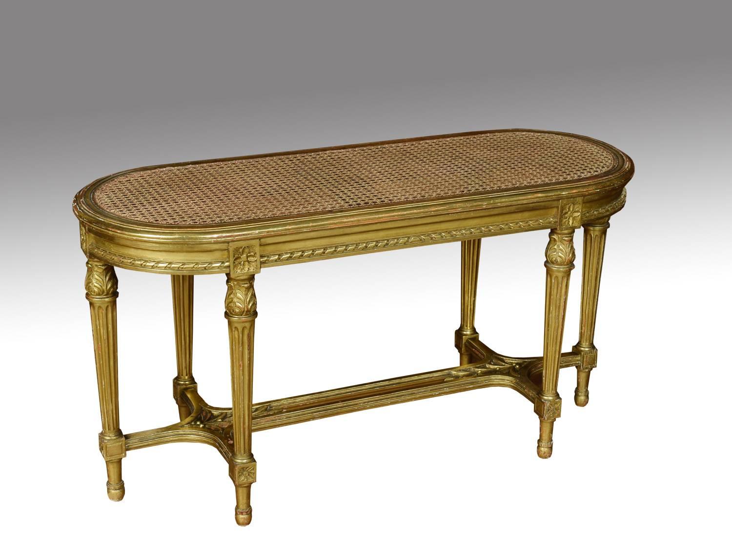 Early 20th century French giltwood oval window seat, having removable upholstered cushion above the shaped bergere seat, within a channelled frame. Above a rope effect frieze raised up on six acanthus leaf and fluted column legs united by leaf and