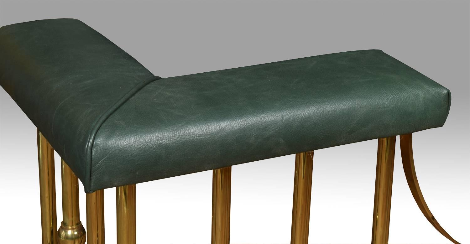 Brass club fender, the green leather upholstered L-shaped stools on turned supports and plinth base.

Dimensions:
Height 23 inches
Internal measurements
Length 54 inches
Depth 15.5 inches
External measurements
Length 61 inches
Depth 18.5
