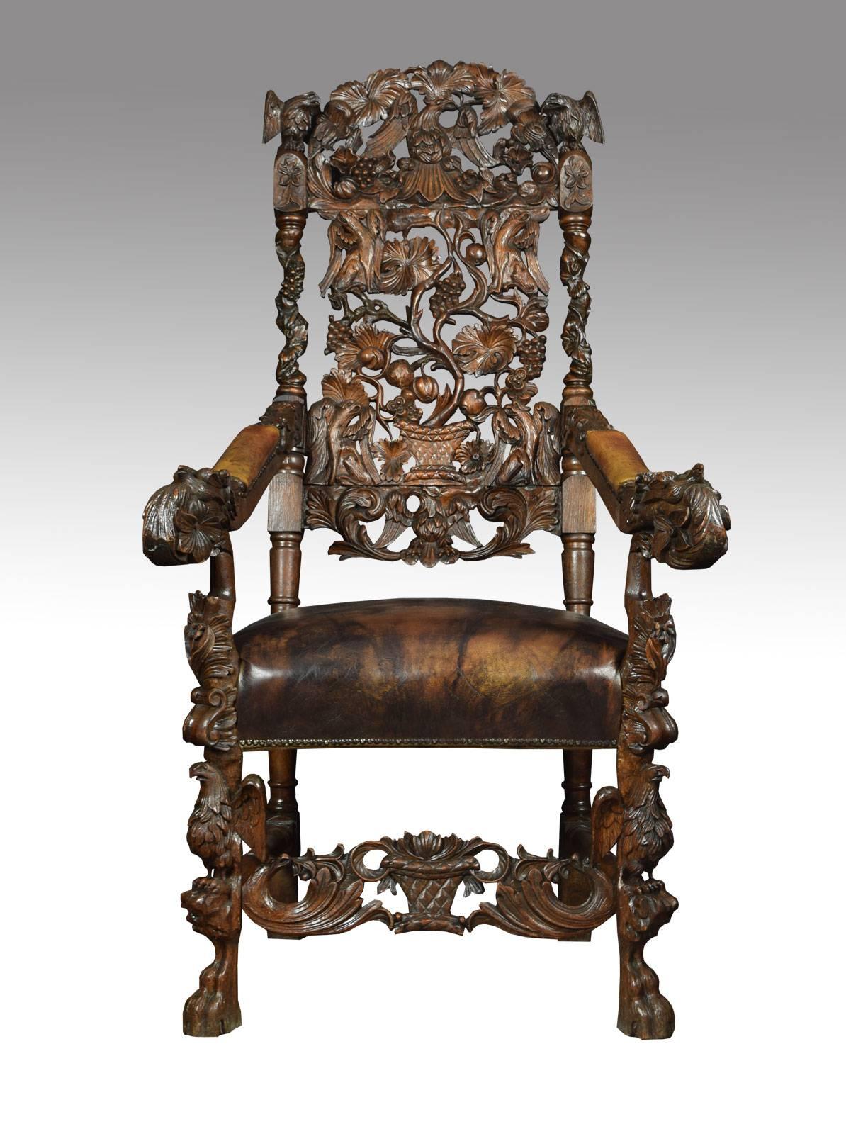 Monumental pair of Victorian carved oak armchairs, in Black Forest style, each with a carved eagle and grape and vine pierced panel back, out-curved leather arms and overstuffed seat raised on heavily carved front legs terminating in paw feet united