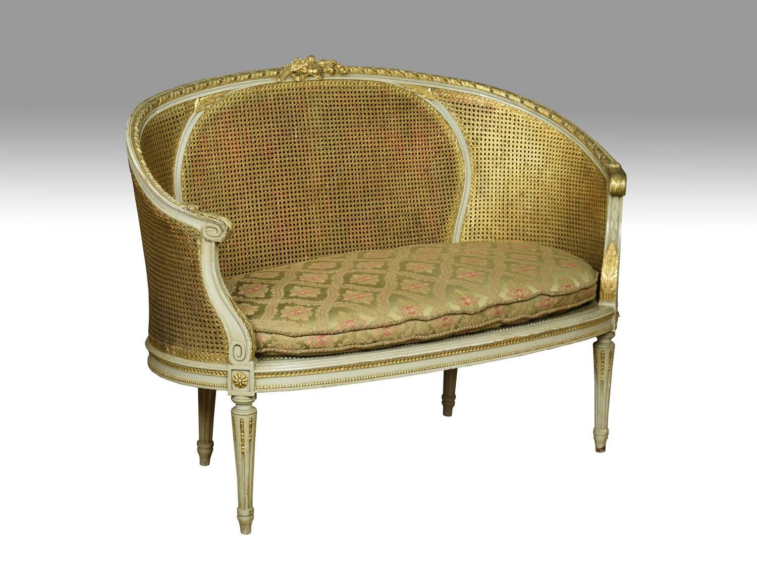 French Louis XVI style canape´ settee, the carved rail in the typical manner of the period with highly detailed ribbon work along the crest among foliage, the frame a repeating motif of detailed leaves. To the scrolling acanthus caped arms, flanking