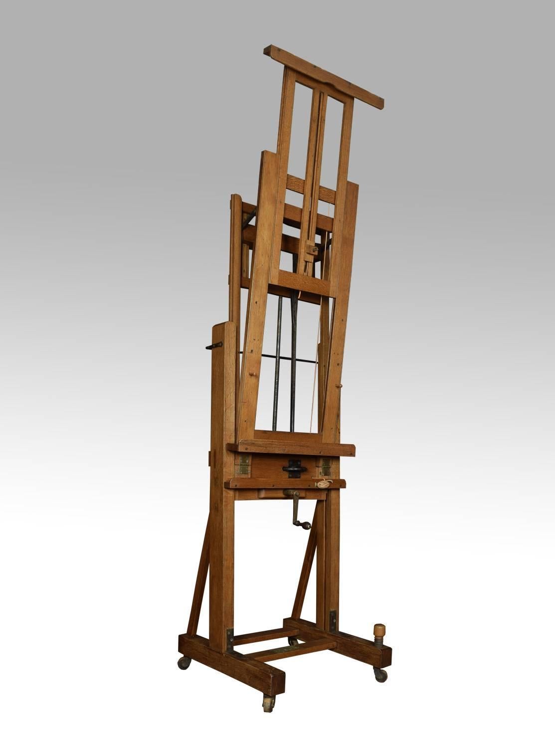 Large oak Windsor and Newton artist’s fully adjustable studio easel raised up on trestle base terminating in four lignum vitae casters

Dimensions
Height 121 when fully extended 65 inches when closed
Width 27.5 inches
Depth 28 inches.