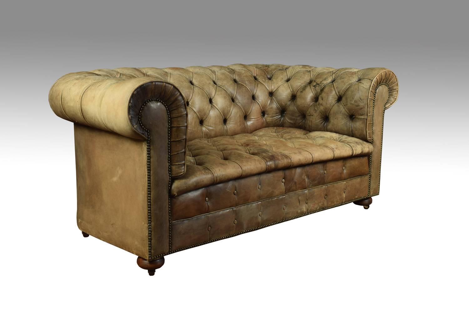 Two-seat light brown coloured leather Chesterfield sofa, partially sun bleached in places, on bun feet with brass ceramic castors. Good solid condition, the leather is soft, nicely worn in.
Dimensions:
Height 31 inches height to seat 17.5