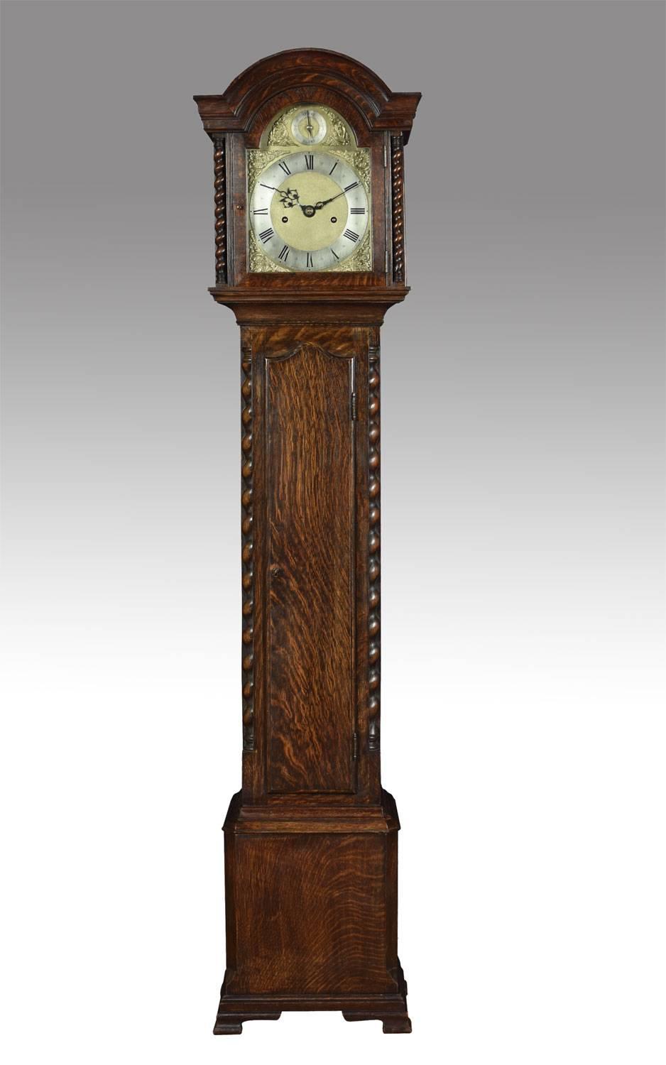 Oak cased grandmother clock, the arched hood to the brass dial engraved with gilt-metal Roman numerals and decorated foliated face with auxiliary dial for setting the striking chime and silent. The eight-day two-train movement with anchor escapement