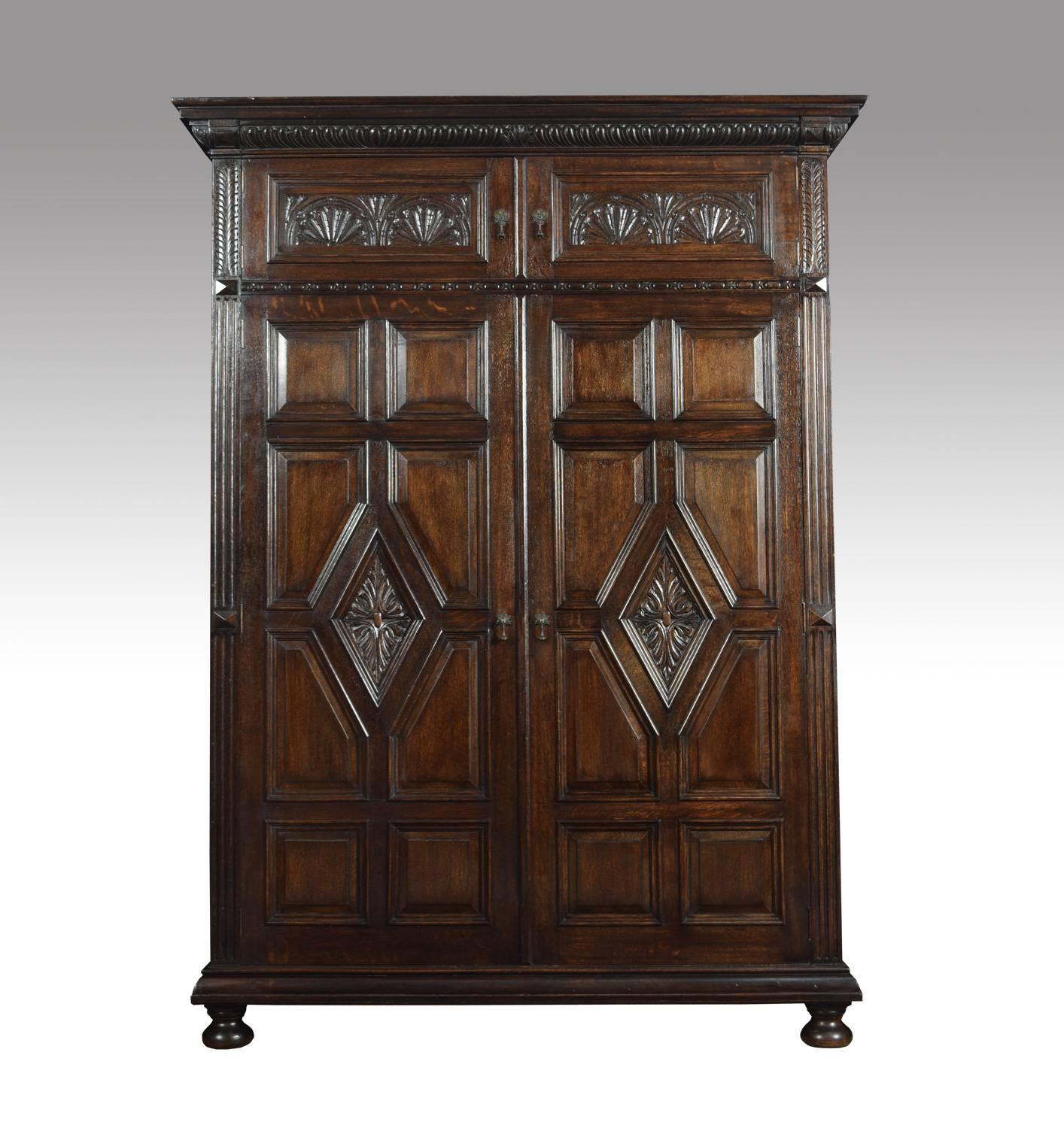 Large oak hall robe, the finely carved moulded cornice, above a two short and two long panelled doors with carved geometric design. Opening to reveal large hanging and storage area. All raised up on bun feet.
Dimensions
Height 81 inches
Width 60