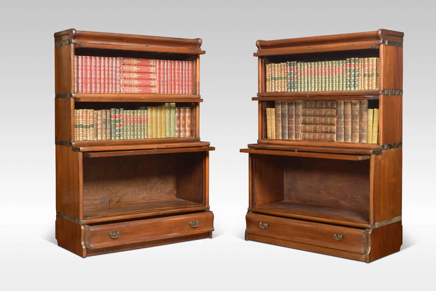 Pair of mahogany globe Wernicke bookcases, the moulded top above two-section with glazed doors and panelled mahogany door below, raised up on a plinth base with single long draw.

Dimensions
Height 48.5 inches
Width 34.5 inches
Depth 15 inches.