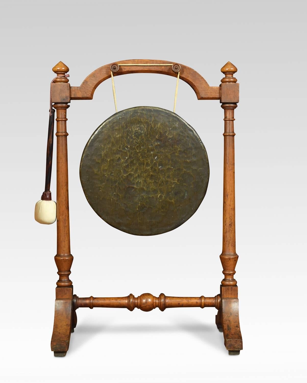 Late Victorian walnut framed brass dinner gong and beater, the stand having carved finials above two turned supports having suspended brass gong to centre raised up on shaped feet.
Dimensions:
Height 33 inches
Width 21.5 inches
Depth 13.5