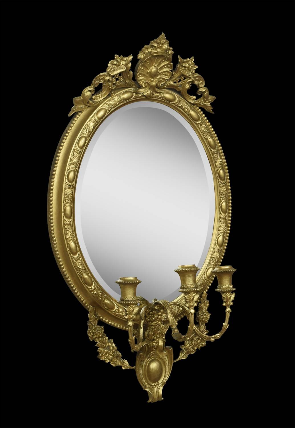 Pair of 19th century gilt composition oval girandoles Mirrors. The cresting centred with a cartouche and foliate scrolls with three candle braches, regilt surrounding the original beveled mirror plate.
Dimensions:
Height 31.5 inches
Width 18