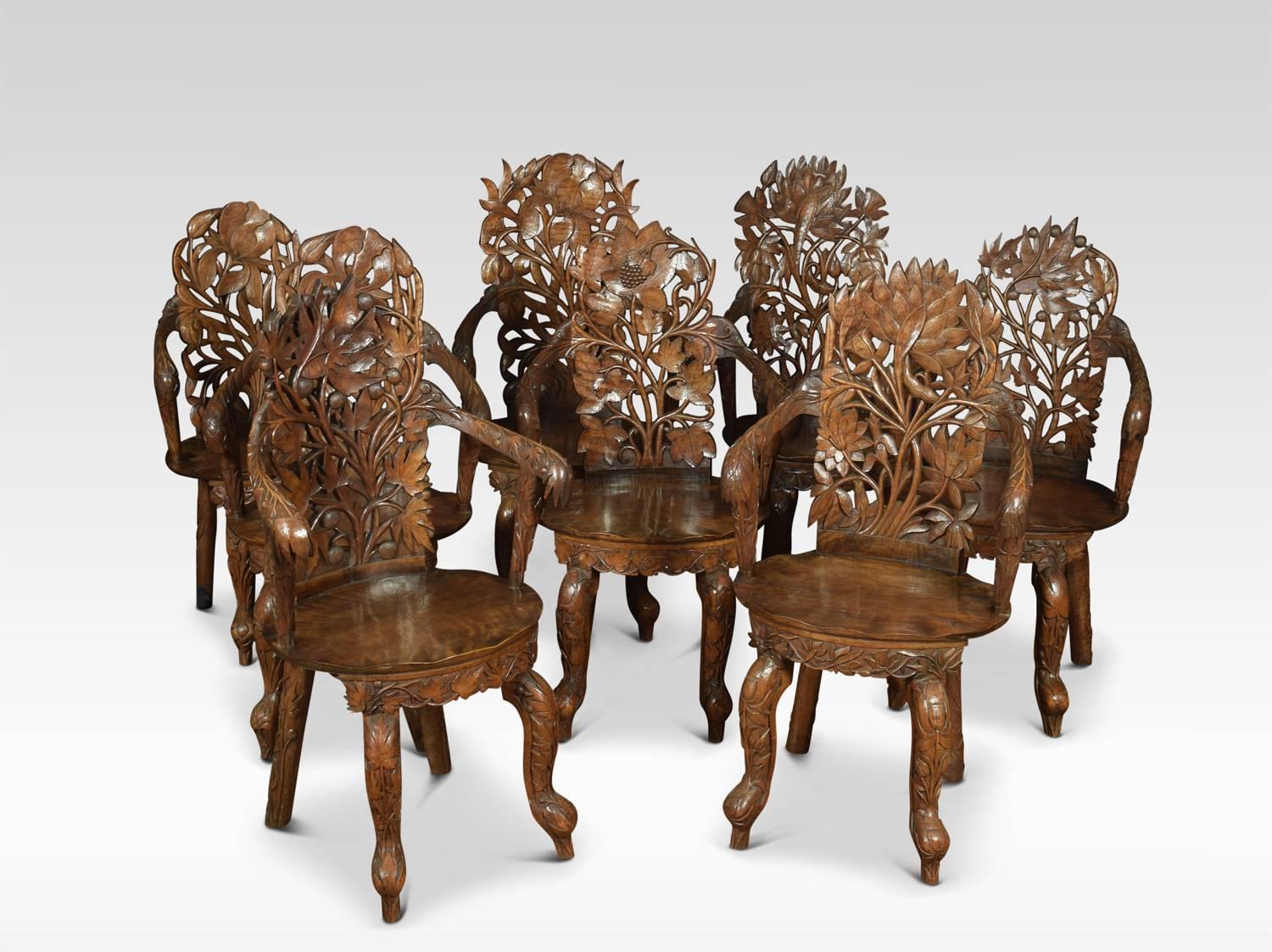 Anglo-Indian carved dining suite. The oval walnut dining table with unusual pierced carved top opening to incorporate one additional leaf all raised up on leaf carved cabriole legs

The eight walnut dining armchairs all of different designs having