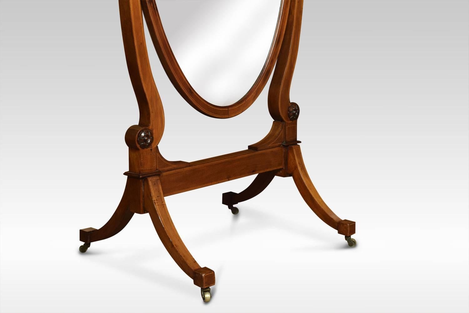 Mahogany inlaid Edwardian cheval/dressing mirror. Having a oval shaped mirror plate with line inlay, supported on swept mahogany supports with brass cup castors

Dimensions
Height 69 inches
Width 34.5 inches
Depth 24 inches.