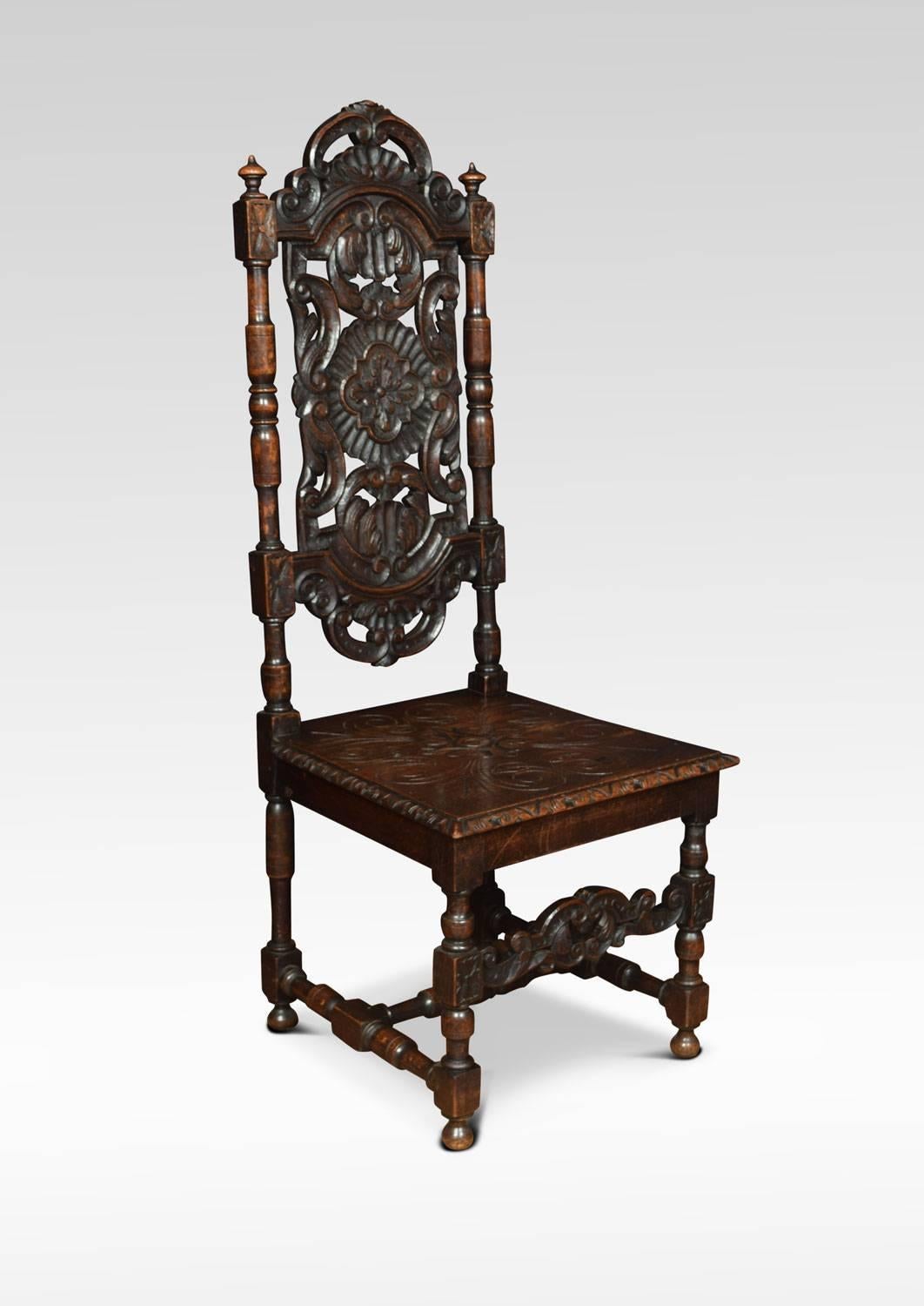 Pair of Victorian high back hall chairs the arched backs with foliate scroll and flower head cresting and pierced vertical splat within turned columns, having a carved oak panelled seat all raised up on turned legs united by H