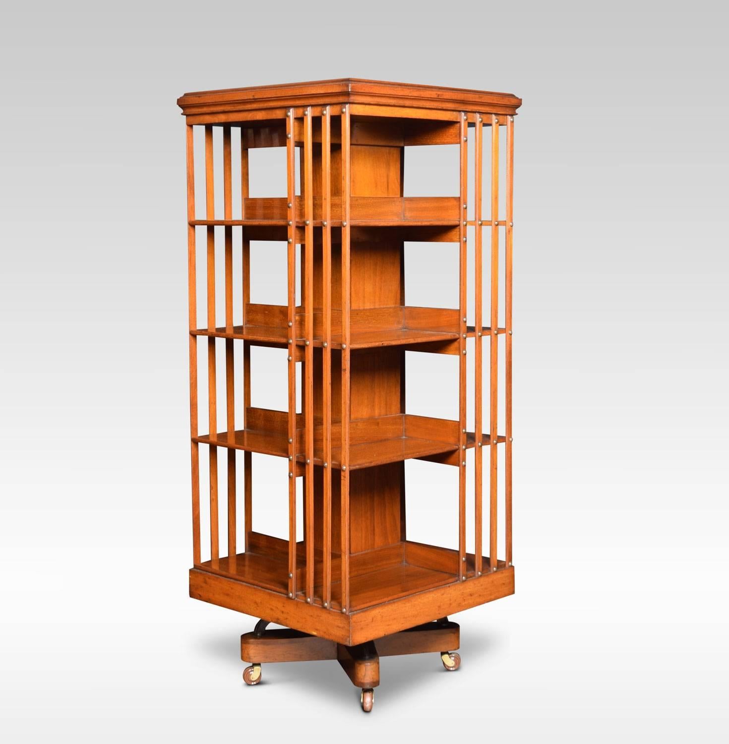 Large walnut revolving bookcase the square moulded top above four tiers with an arrangement of shelves raised up on metal cruciform base terminating in ceramic castors. This bookcase is almost certainly by Maple & Co

Dimensions:
Height 57