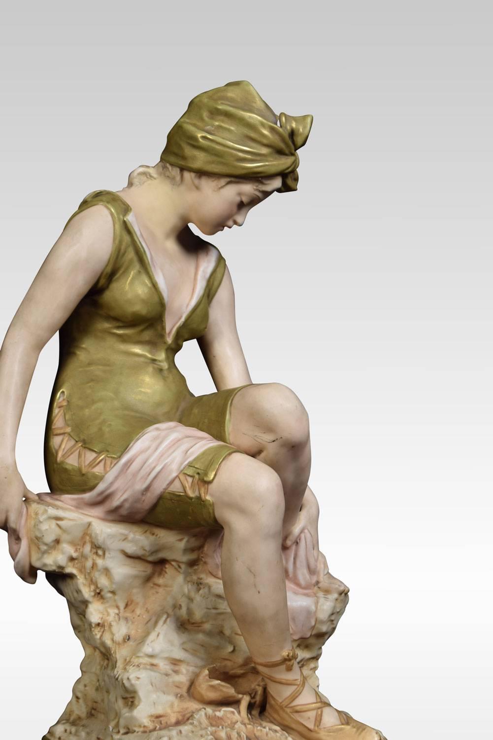 Royal Dux Bohemia porcelain figure of a bather modelled seated on a rock wearing a laced swim suit, head scarf and laced slippers, drying one foot with a towel on canted square base, applied pink triangle.
Dimensions:
Height 22 inches
Width 11.5