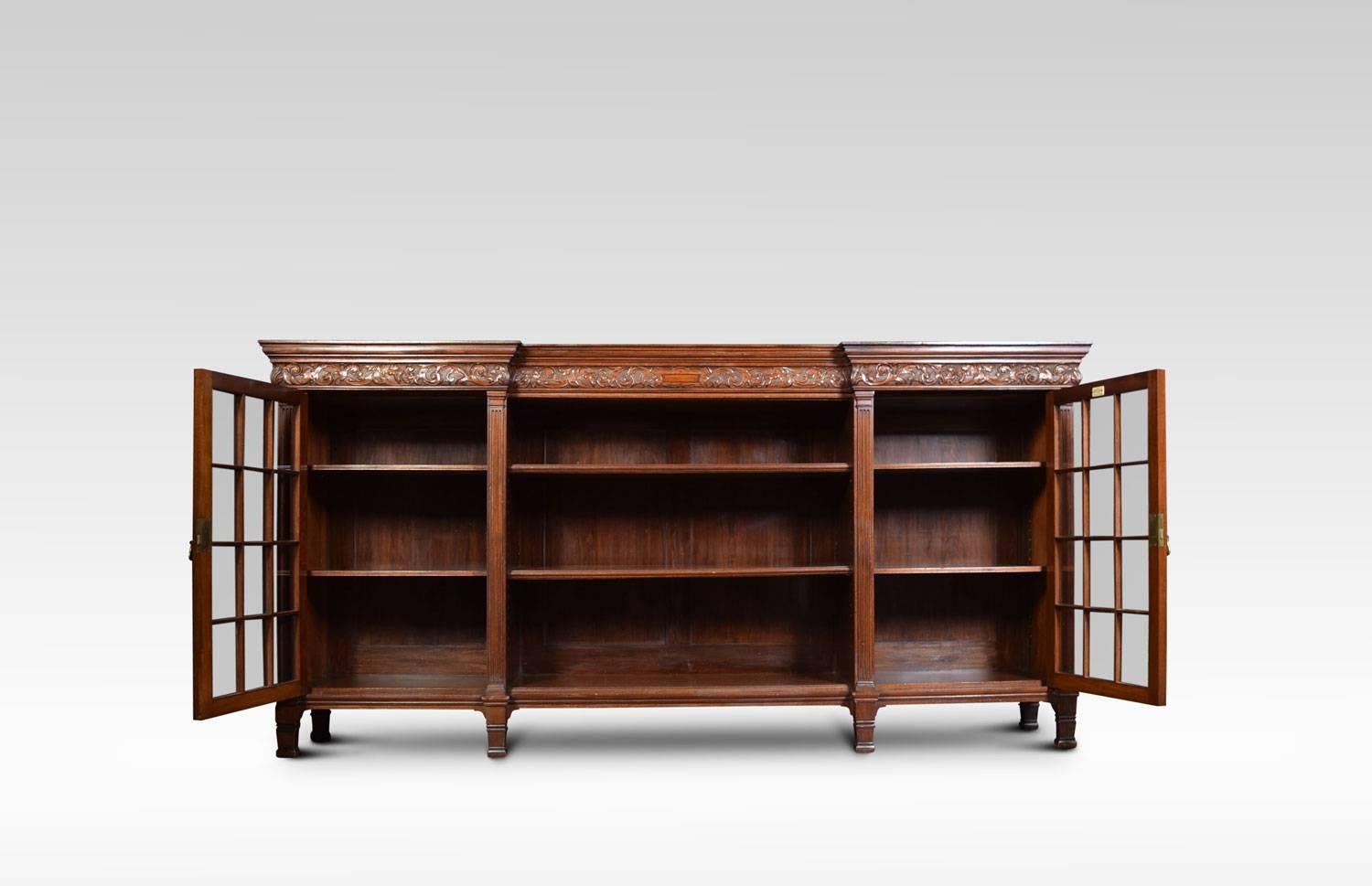 Edwardian Maple & Co carved mahogany dwarf bookcase, the large rectangular inverted breakfront top, above foliate and dragon carved frieze. To the base, the central section with open adjustable shelves, flanked by beaded glazed panelled doors