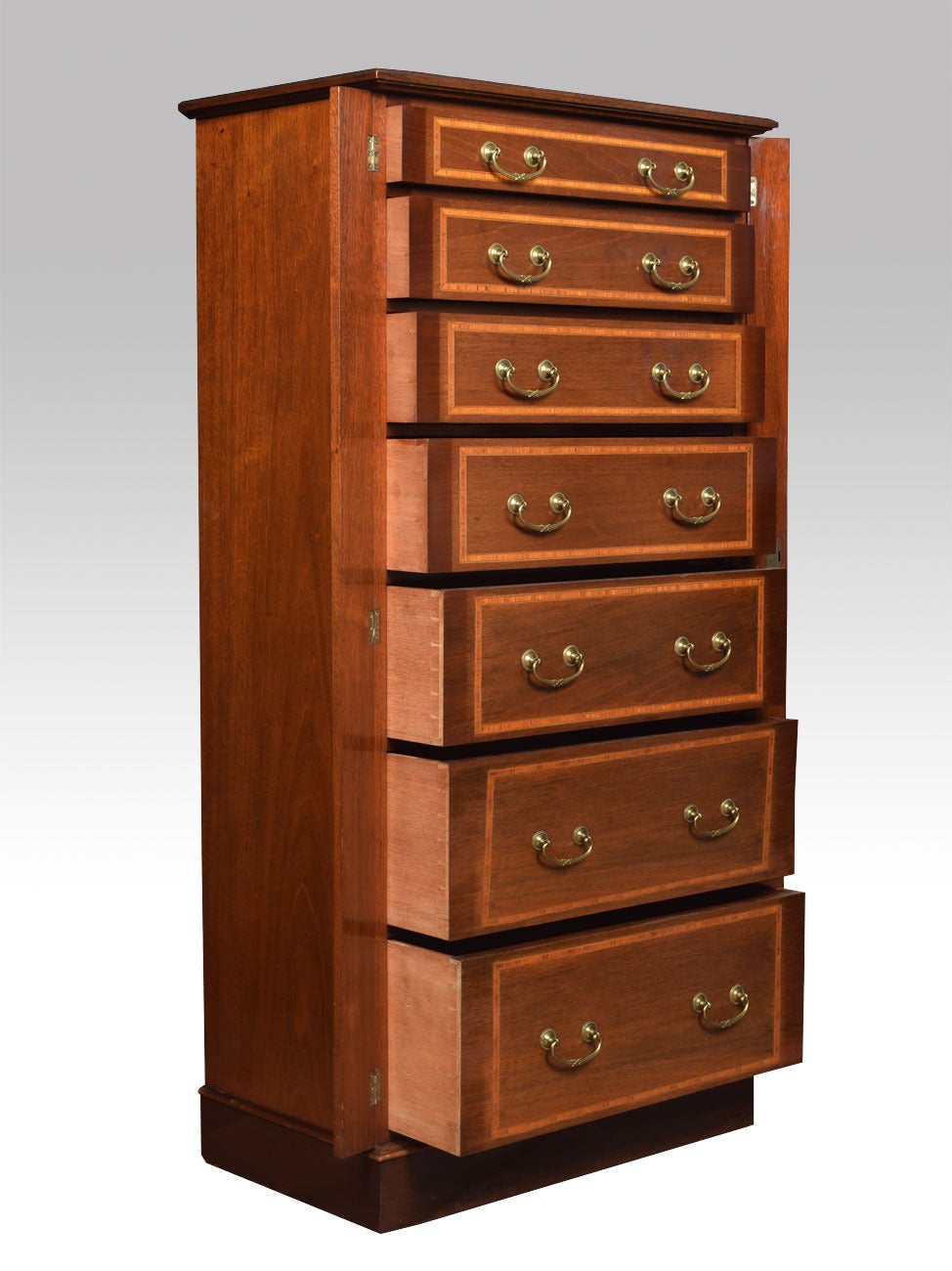 Early 20th century Edwardian mahogany and satinwood string inlaid Wellington chest the rectangular top above 7 graduated drawers each retaining original brass swan neck handles, all raised up on a plinth base.

Dimensions:

Height 52.5