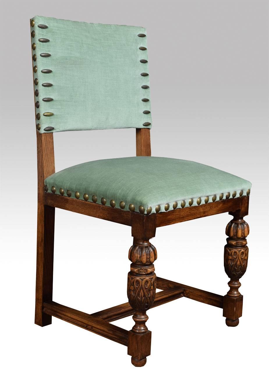 Set of six carved oak dining chairs the square upholstered studded backs above overstuffed seat the carvers with scrolling arms all raised up on bulbous cup and cover front legs united by stretcher

Dimensions:

Carvers:

Height 36.5 inches