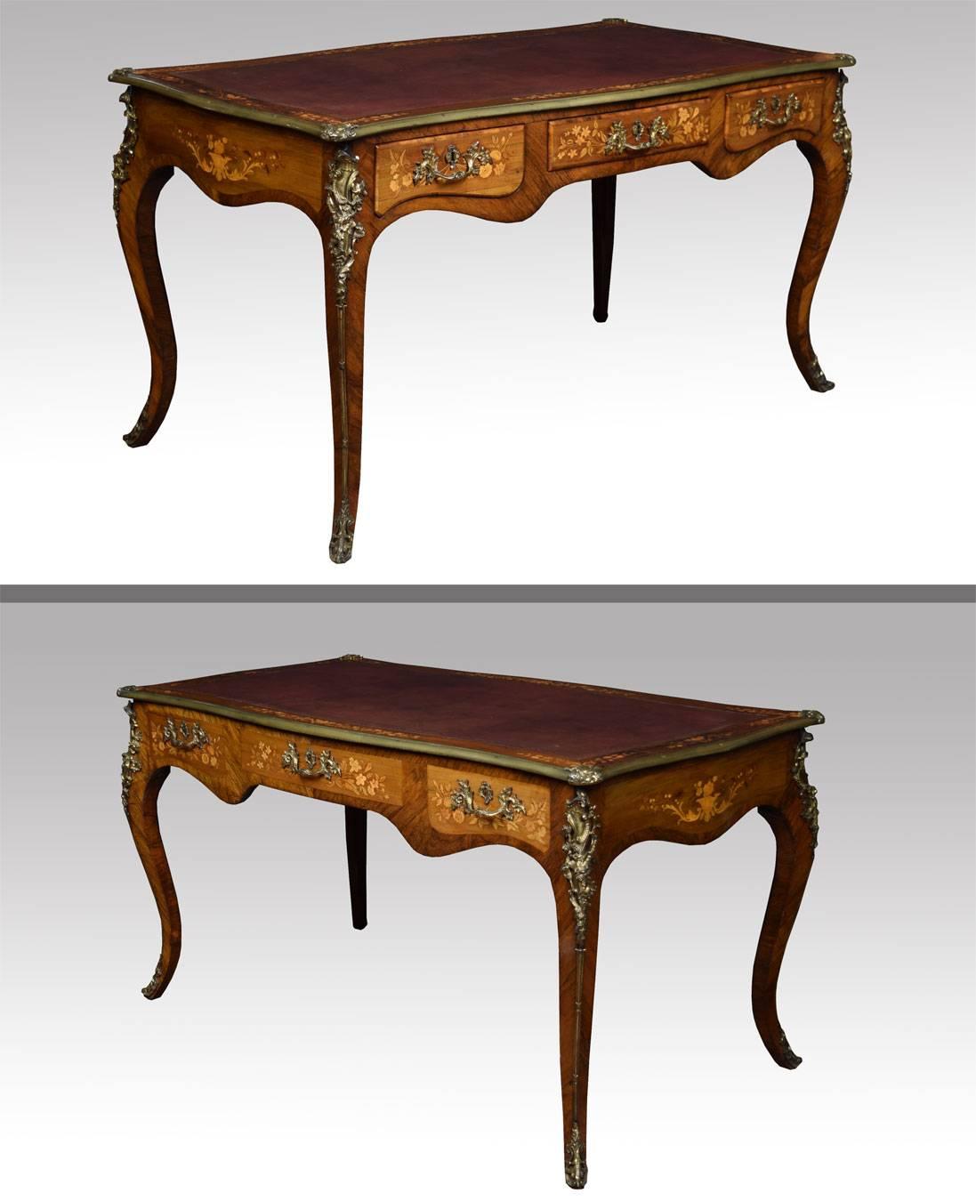 Ormolu-mounted, rosewood, walnut, kingwood and floral marquetry bureau plat, second quarter 19th century of serpentine outline, the tooled leather inset top with a broad band of scrolling foliage encased by an ormolu-band, above three frieze drawers