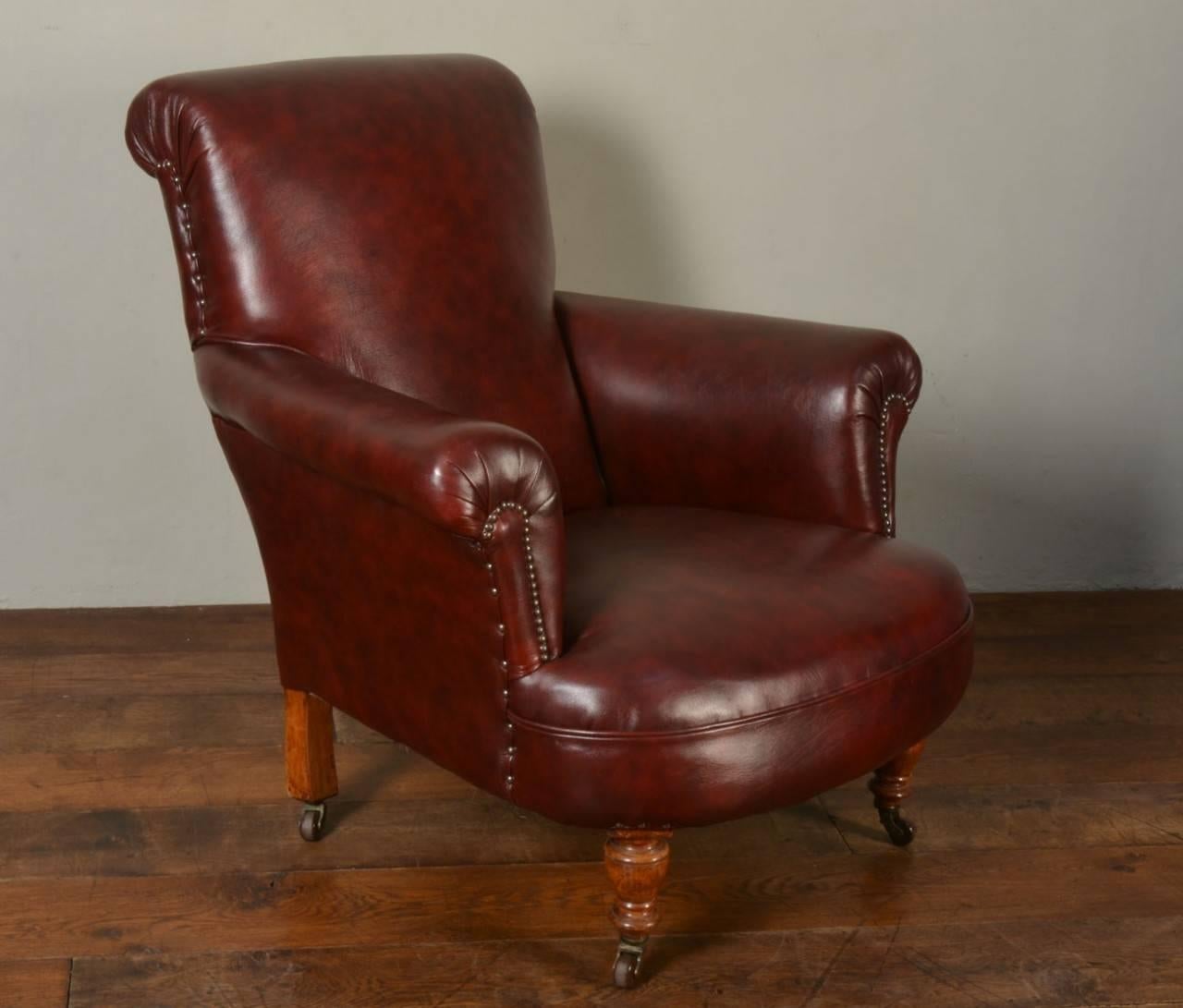 

Pair of Victorian dark red re-upholstered armchairs in the style of Howard, having brass studded arms with shaped backs raised up on turned and ringed tapering walnut front legs terminating in brass castors

Dimensions:

Height 35 inches,