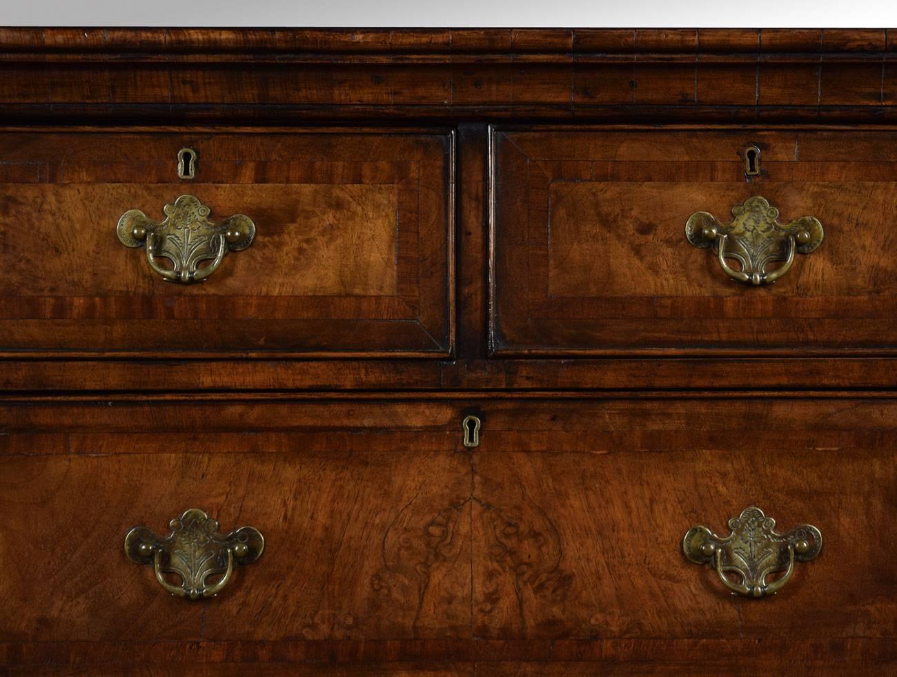 

Queen Ann style walnut chest on stand, the rectangular moulded top above two short and two long draws having solid oak lined draws and tooled brass handles, to the base fitted with three short draws. All raised up on four slender acanthus capped