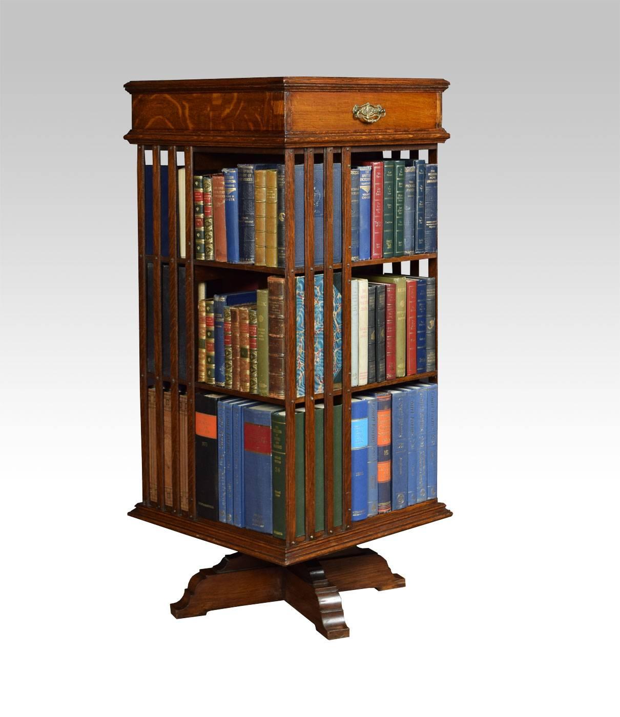 

Oak revolving bookcase with unusual top draw, above three tiers having an arrangement off shelves all raised up on cruciform base.

Dimensions:

Height 45.5 Inches.

Width 20 Inches.
 