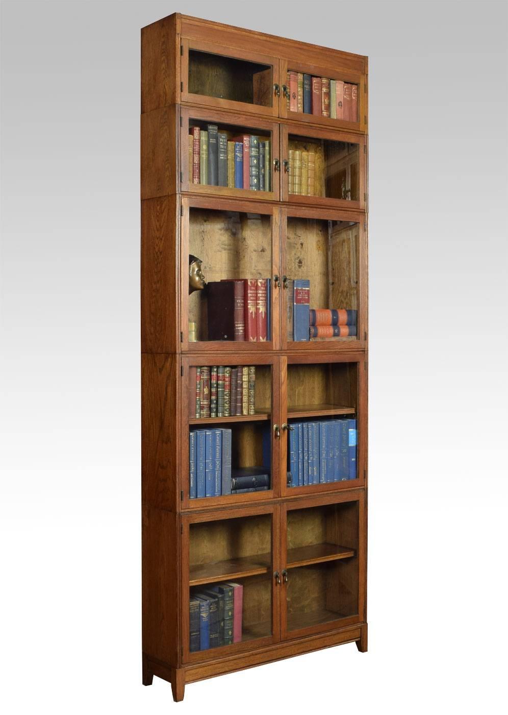 Set of three oak sectional bookcase by E.S.A London, the two small top sections having hinged double doors above three large sections fitted with similar double doors and single shelf, all raised up on square supports.

Dimensions:

Height 91.5
