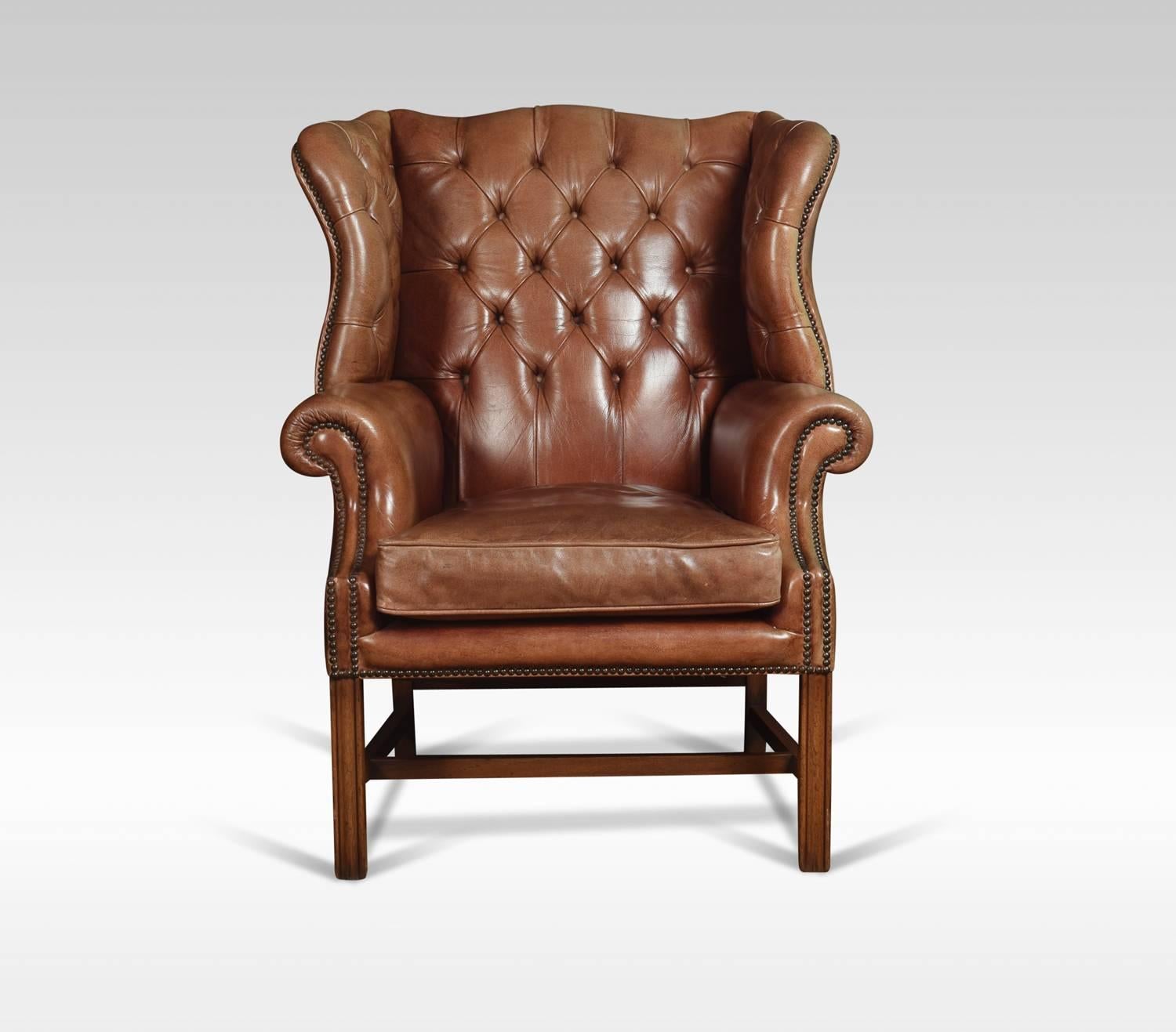 Mahogany framed wing armchair of generous proportions, the arched top above deep buttoned back, upholstered arms and seat in a sun bleached burgundy leather, raised up on square supports united by stretcher
Dimensions:
Height 44.5 inches, height