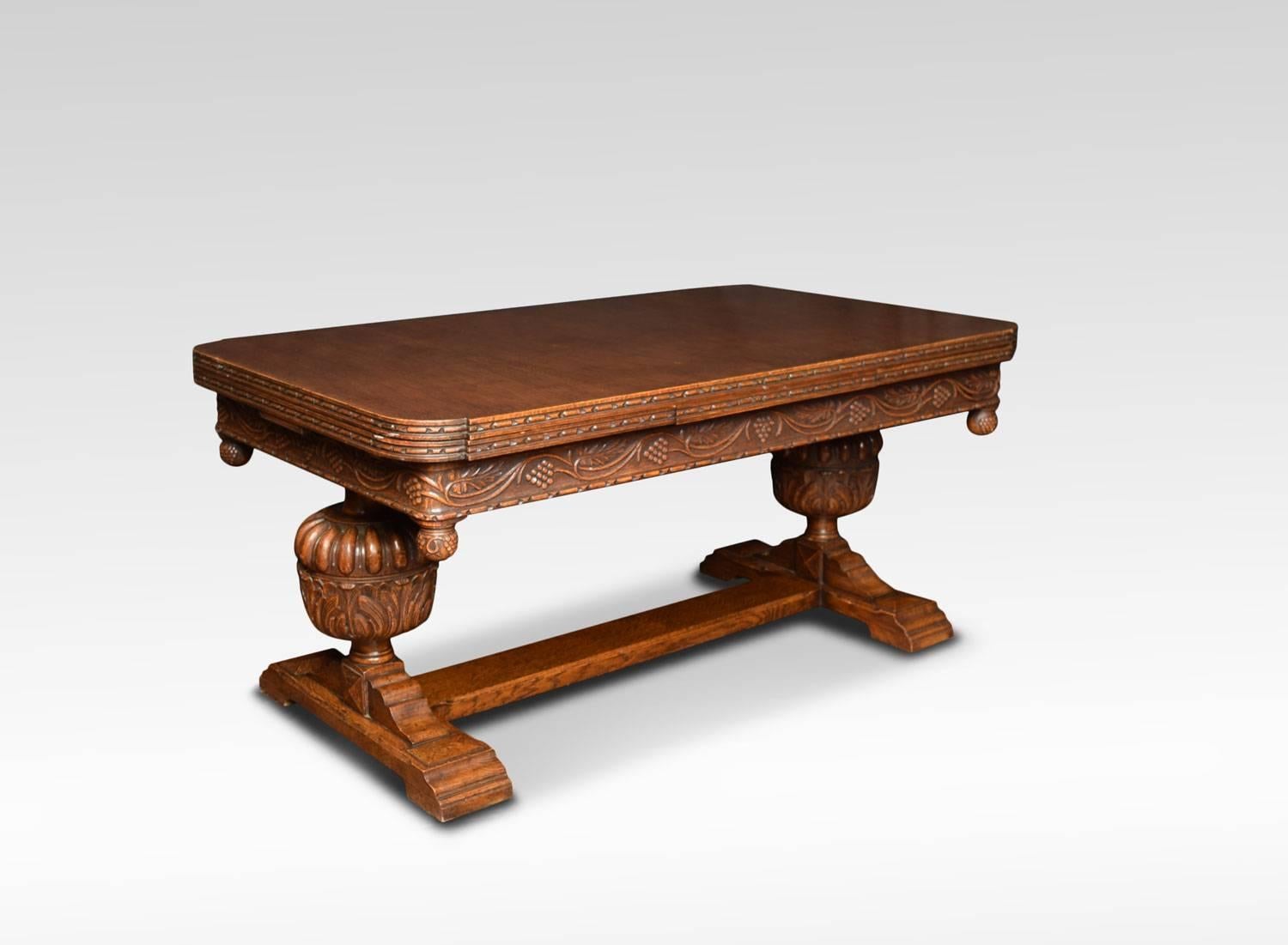 Impressive oak drawer leaf table the large rectangular pull-out top with rounded corners to the frieze decorated with grape and leaf carving. All raised up on substantial bulbous supports terminating in trestle base.
Measure: Height 31