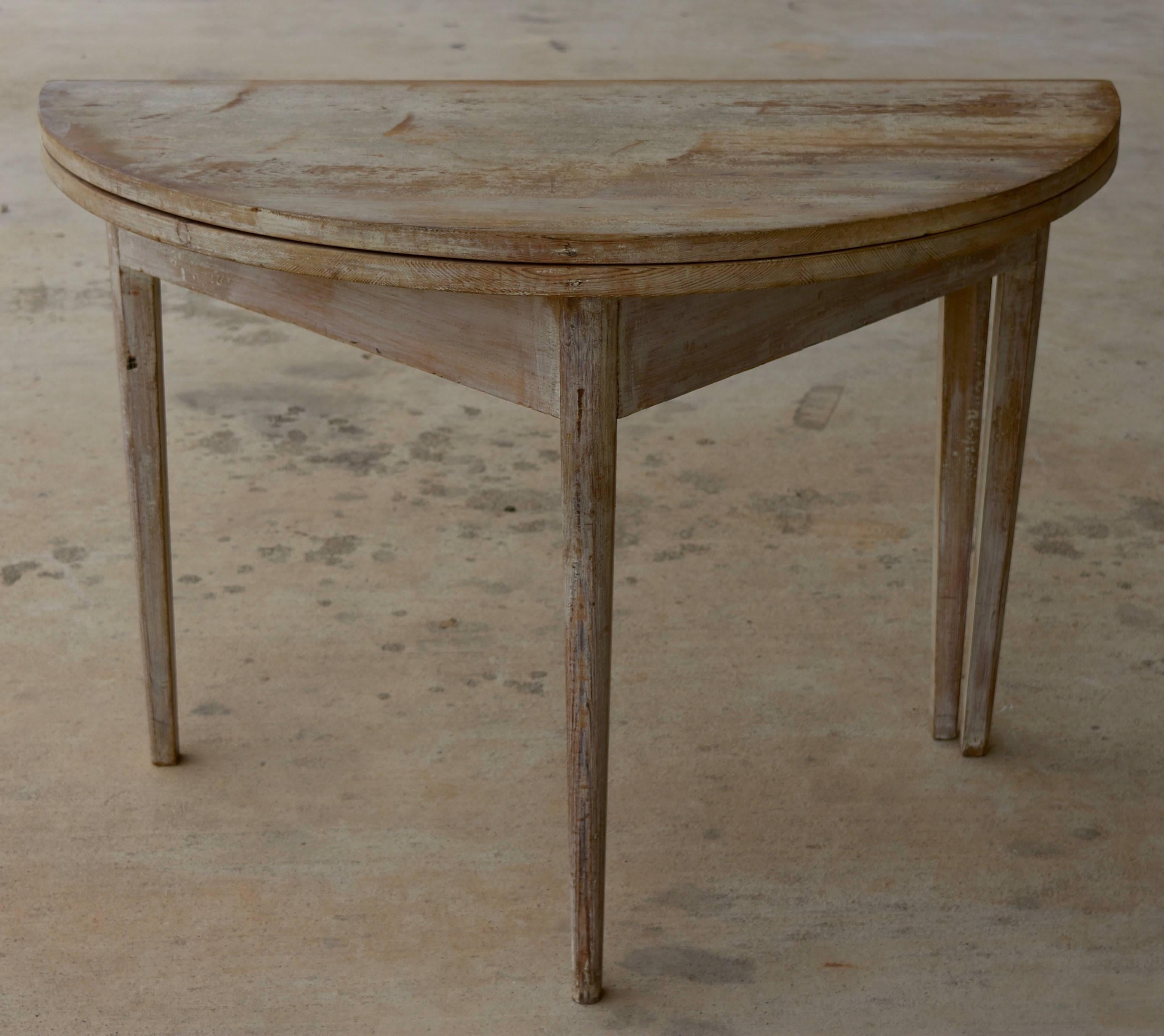 This is a very nice Gustavian style pine scraped back painted demilune table from Sweden that opens to a round table and can seat four people.