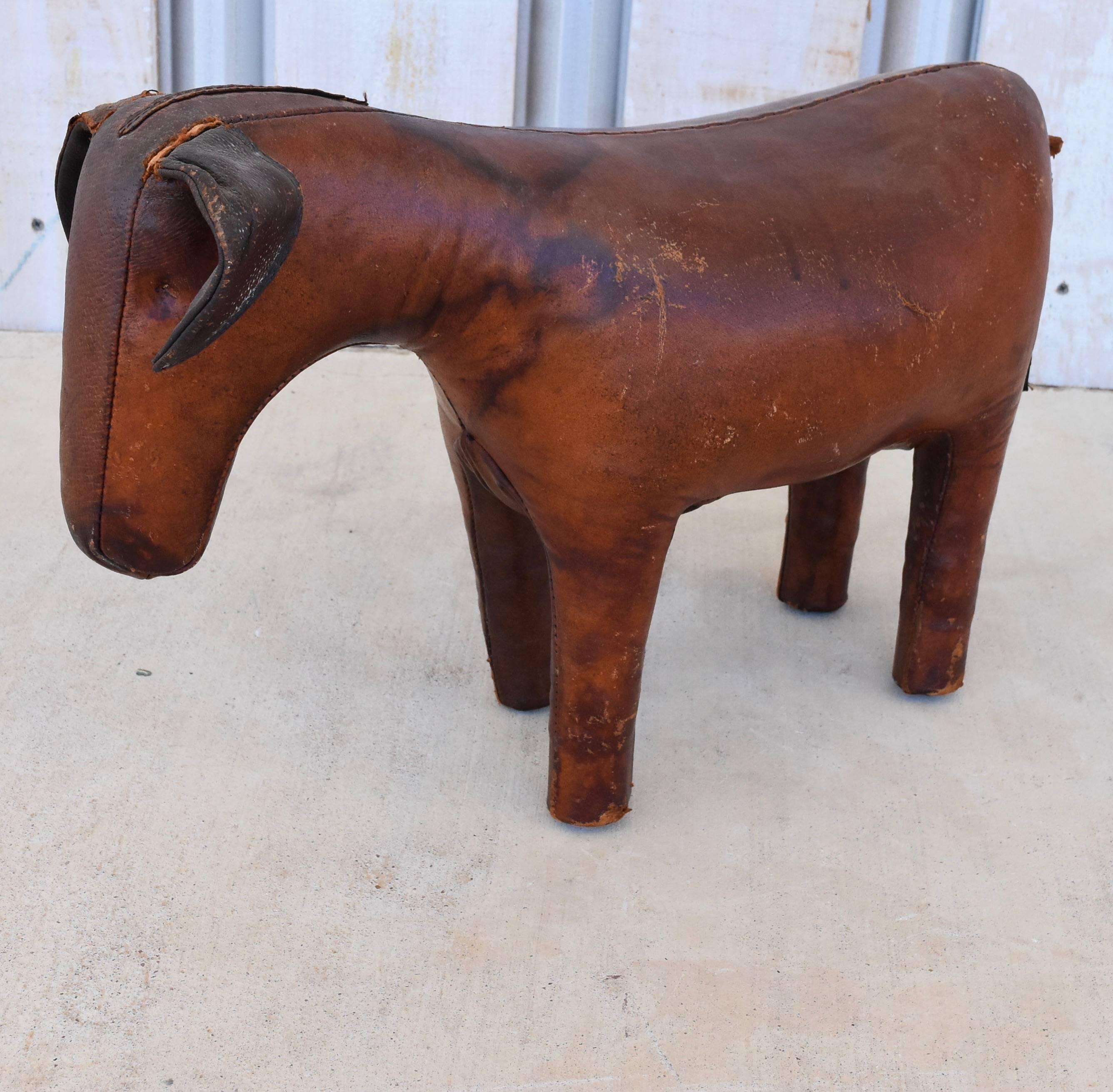This leather donkey footstool is one of several animals produced by the Omersa Co. in England. It is worn with slight scuffs and some stain on the left shoulder. Its tail is intact but very fragile. His main on the top of his head is no longer there