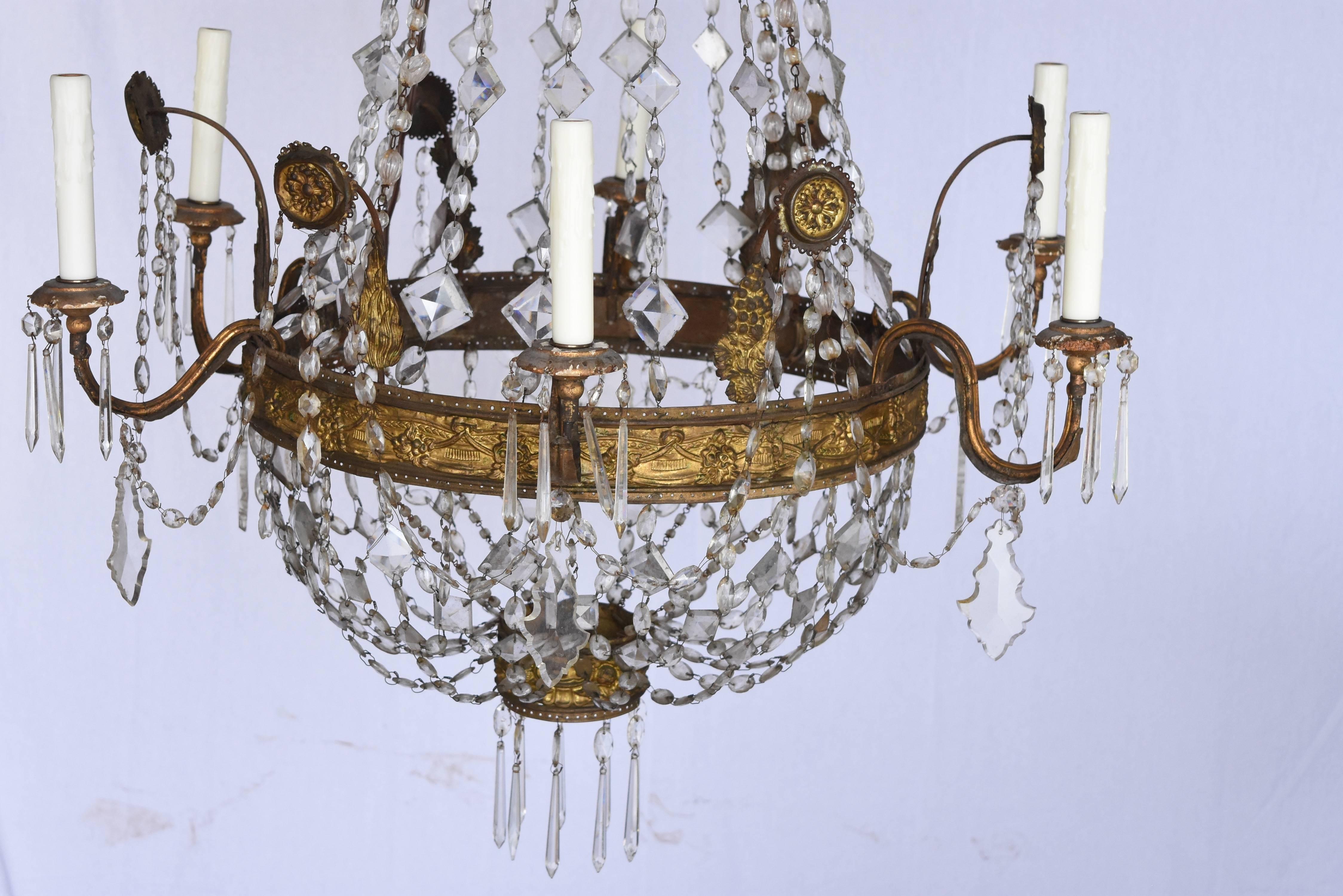 This is a beautiful late 1700s Italian chandelier from the Genova area of Italy.
Its hand-hammered repousse style is elegant and the way the crystals sweep make it airy and light. It has be newly rewired for us standard as well.