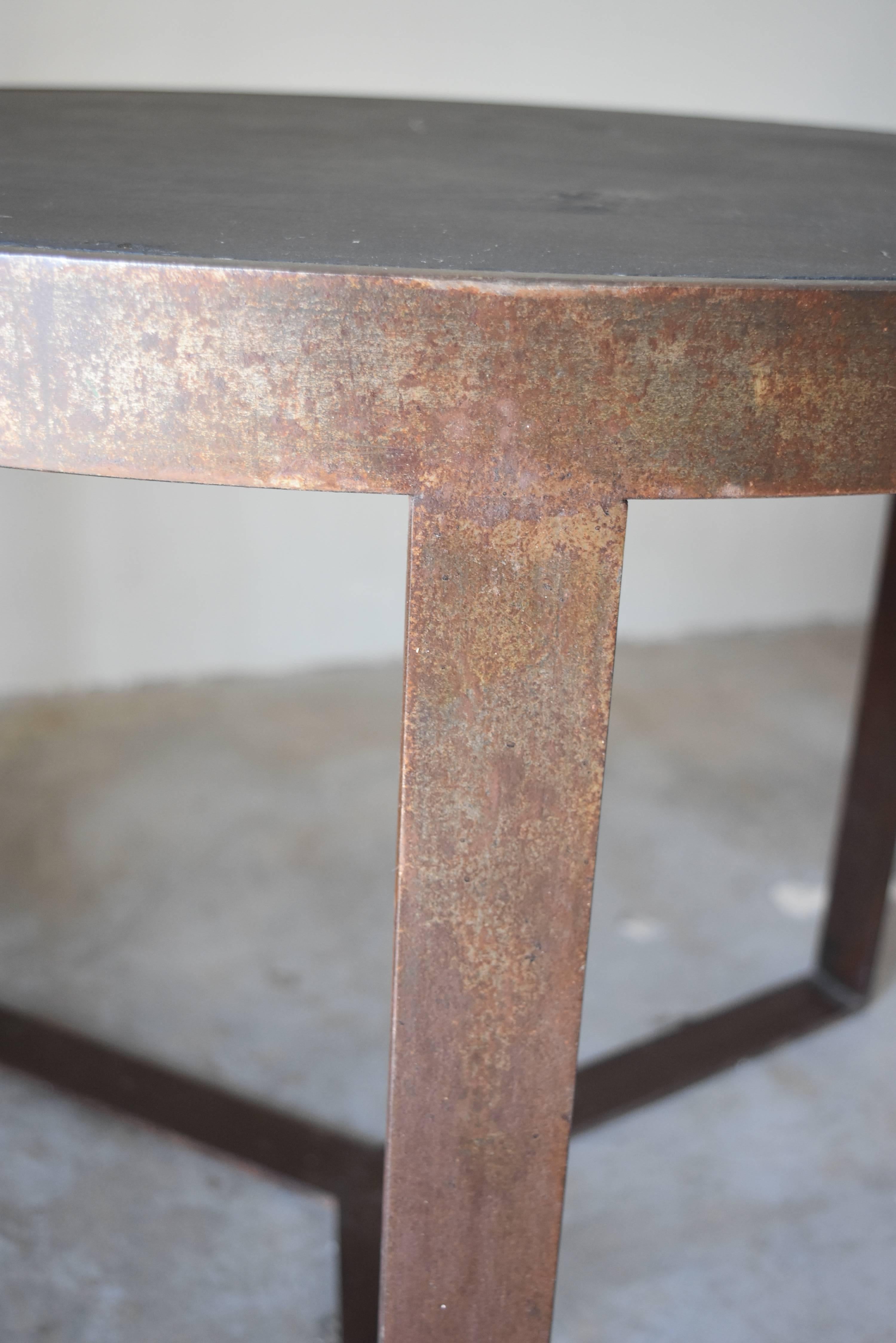 This is a heavy iron table handcrafted in Spain for me. It features black iron but photographed gold with the flash. It's black though. The top is inset with slate and doesn't come out. It makes a great coffee or side table.