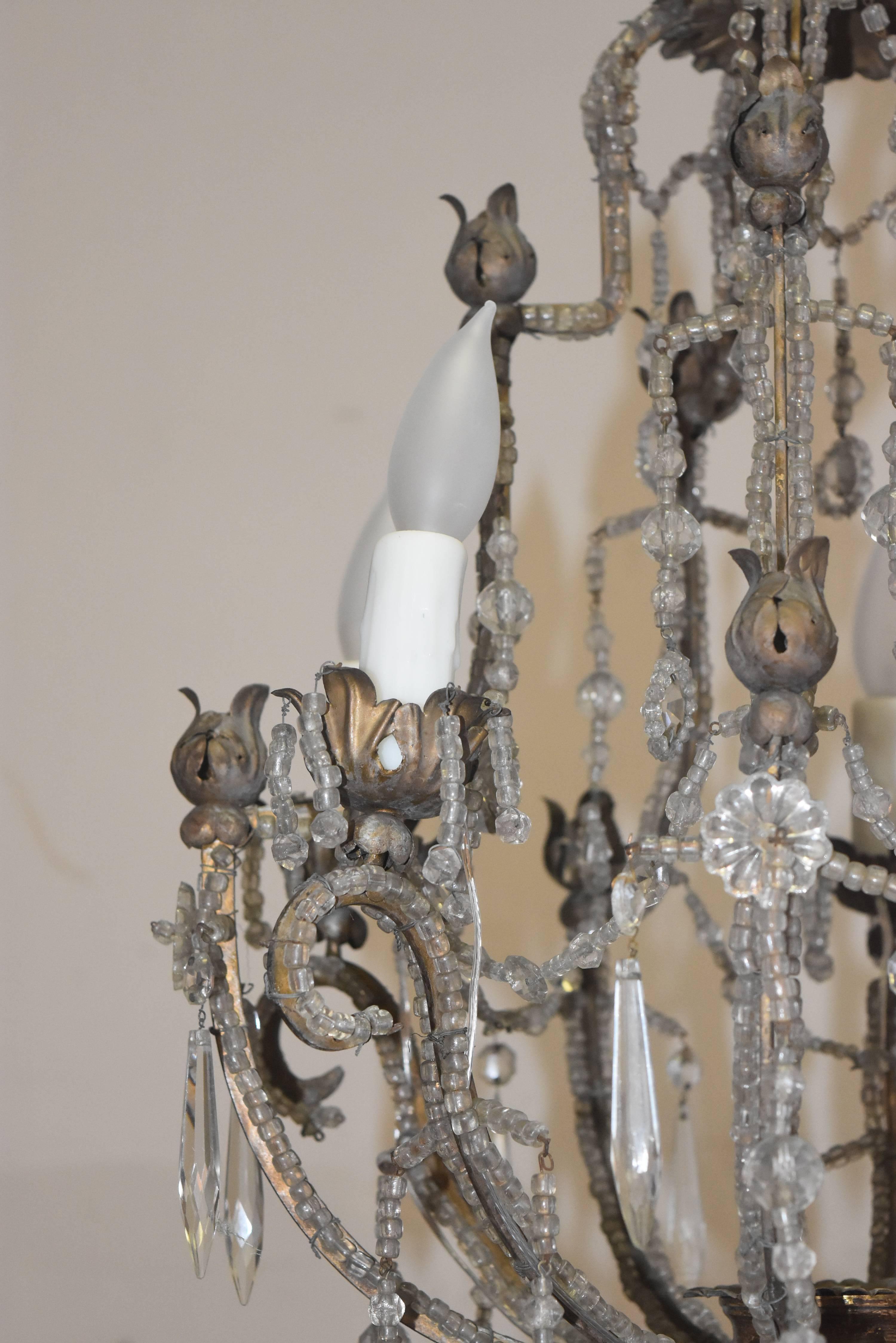 This little gem is a crystal chandelier from Italy that is wrapped in beads and has the original filagree metal pieces that it hangs from instead of a chain. It has been newly wired so it's read to go. Measures: 19 W x 26 T.