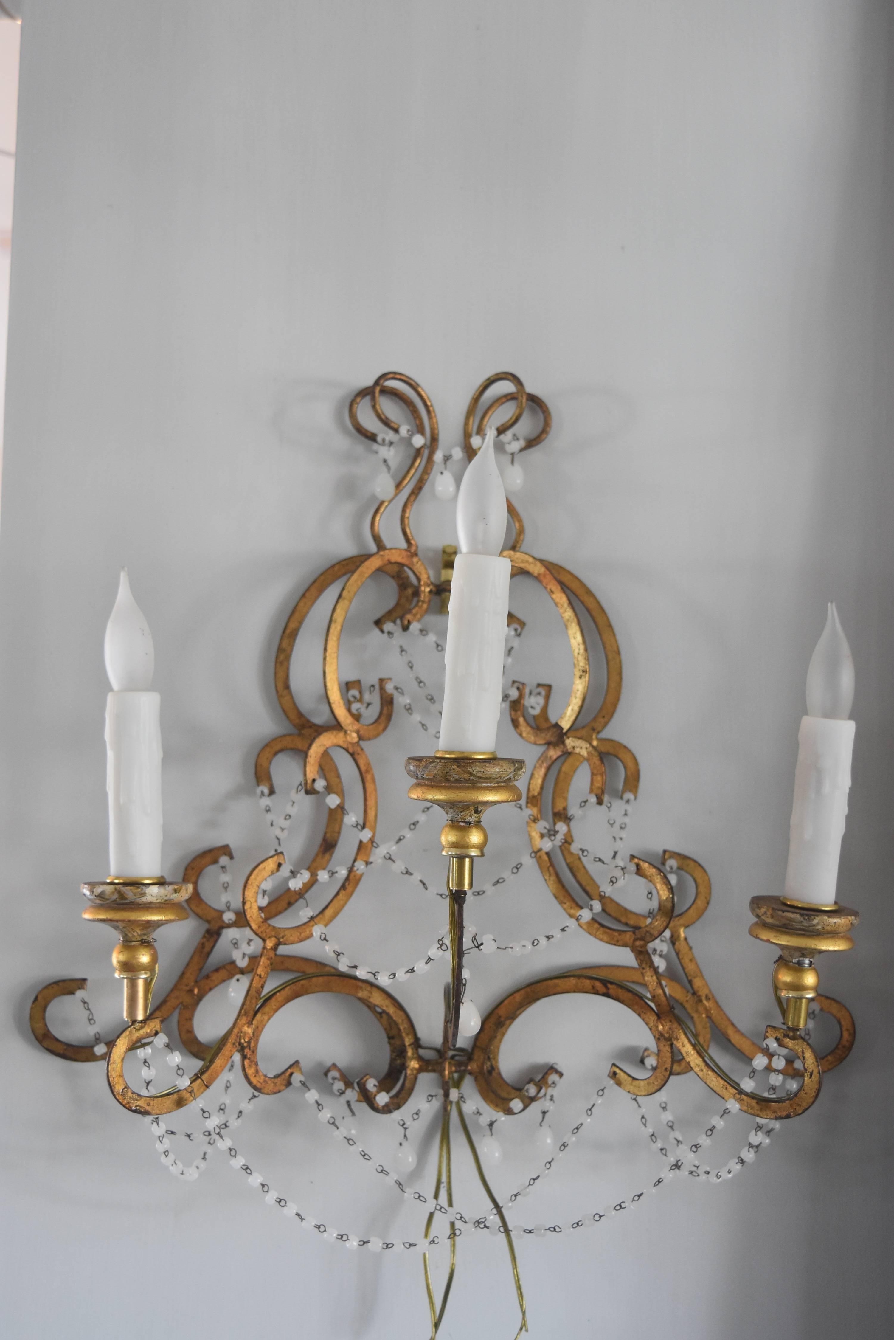 These little three-arm Italian gilt sconces have that nice airy look and the prettiest color of white milk beads. The gilt bobeches give it that extra dressy look.