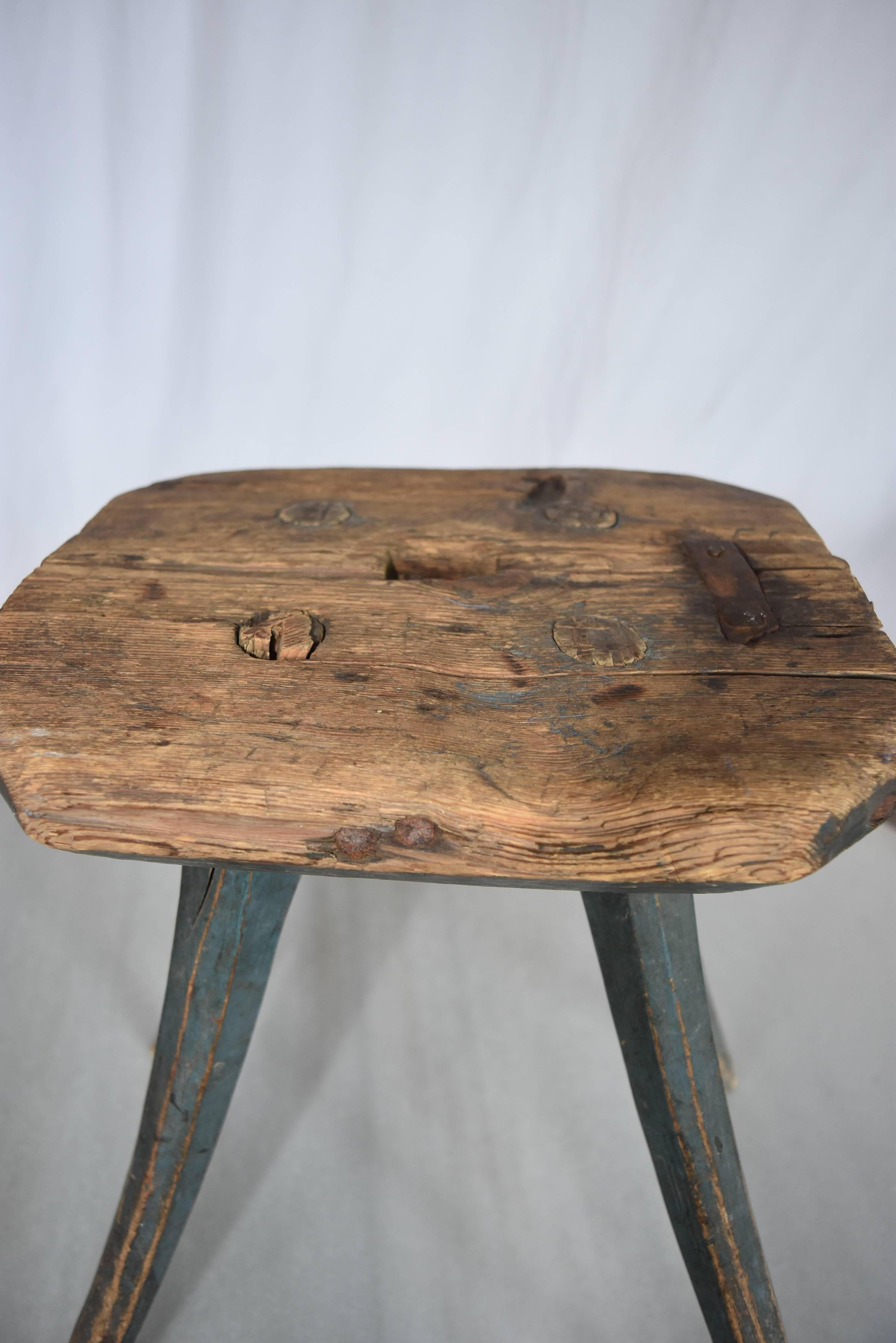 This little gem has it's original blue paint from Sweden. It has old iron repairs to the natural oak top and legs are saber style. It is a Folk Art stool that was probably used for milking or just as a little stool to sit on. Because of the old
