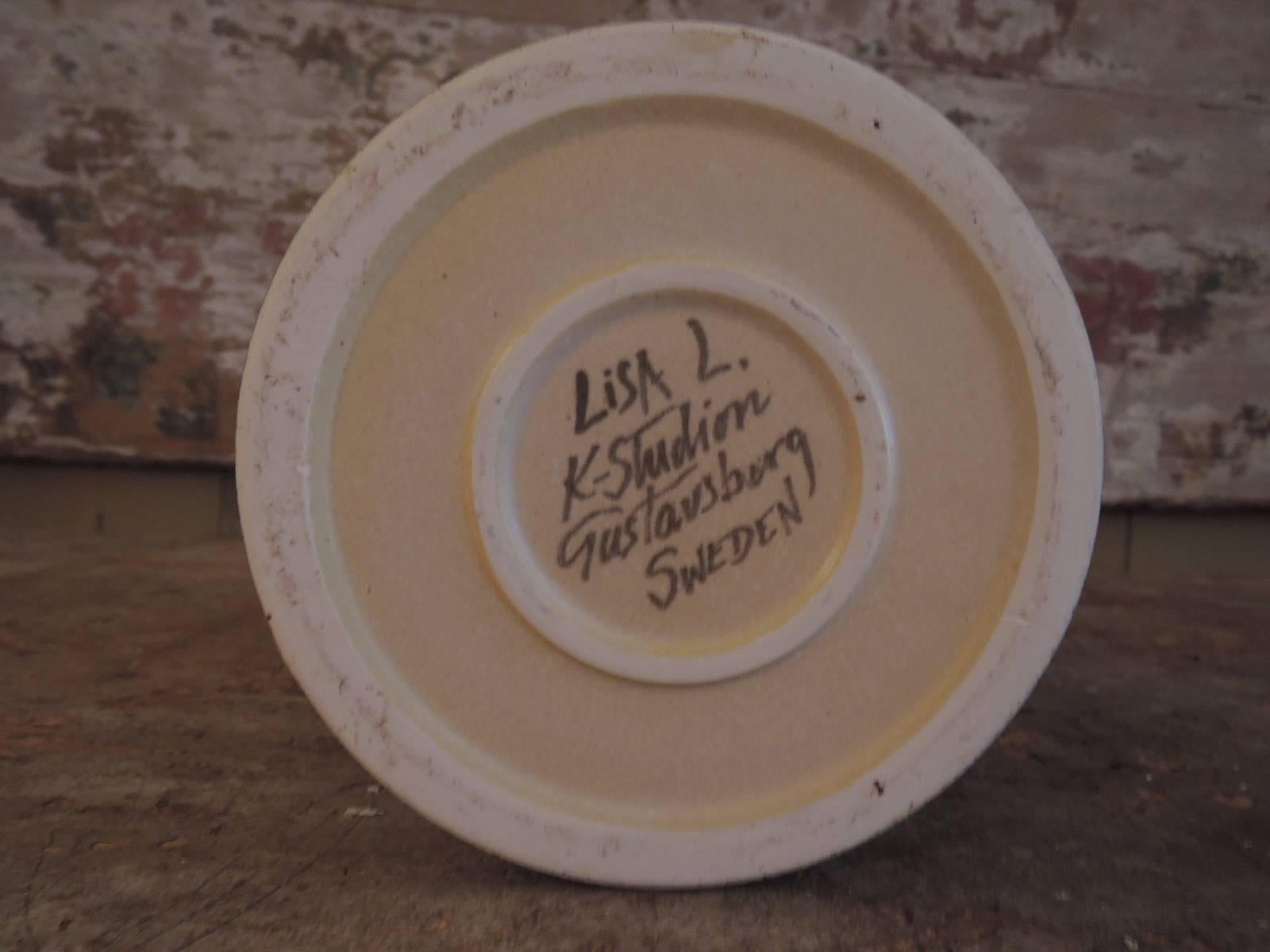 Tall bowl with a face, by the Swedish artist Lisa Larson.
Grey or green pointing glaze stoneware.
Signed by hand under the piece Lisa Larson, K-studion, Gustavsberg.