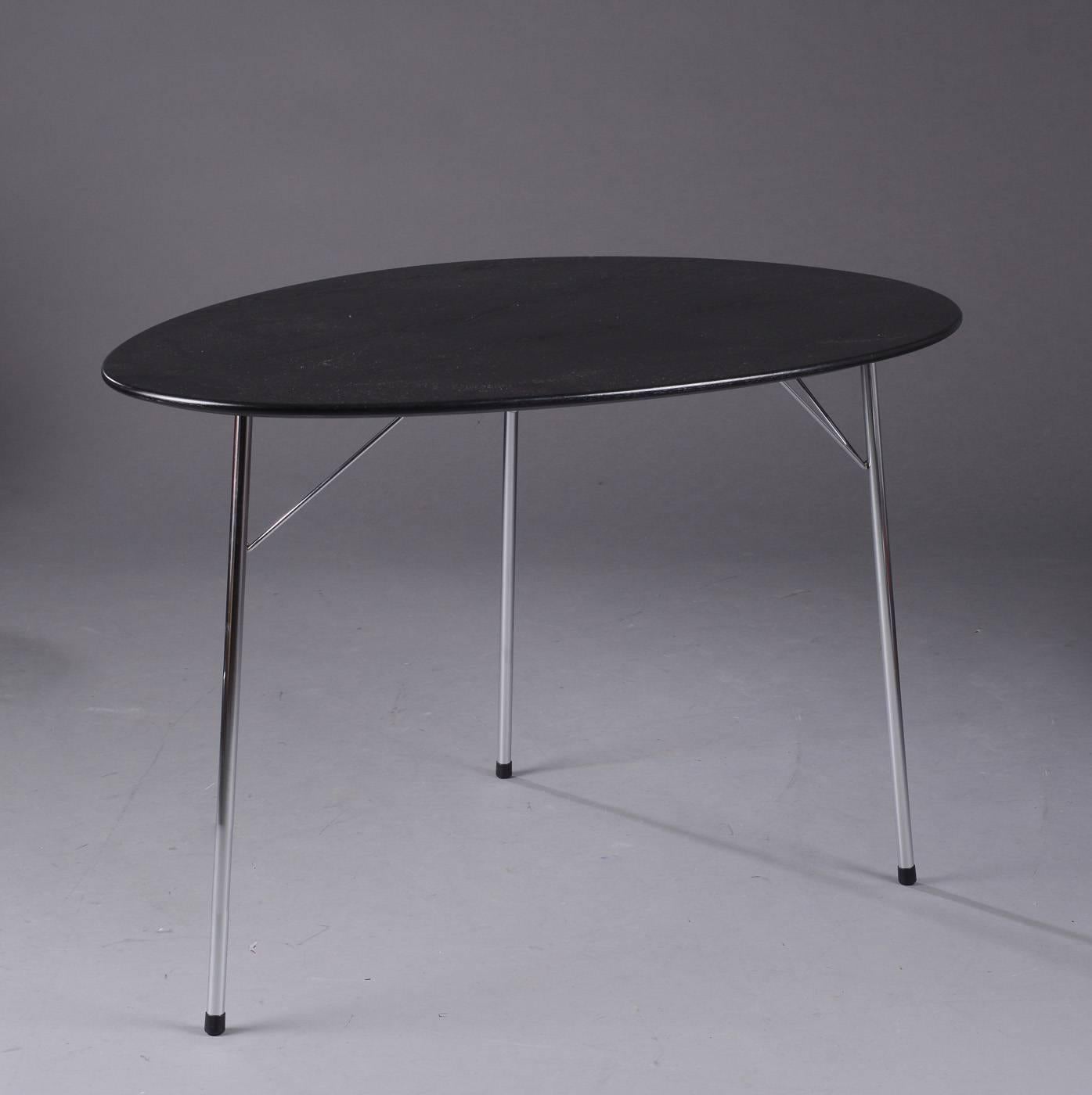 A nice composed of one egg-shaped table, model 3603, with black glazed ash veneer top, chromed steel legs and three 